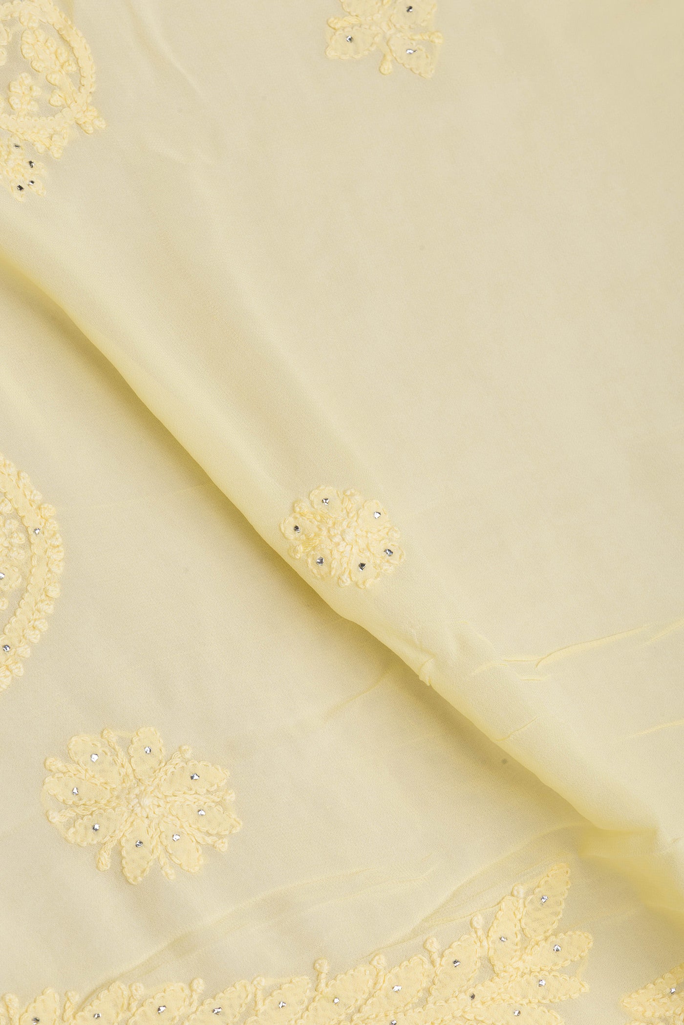 Close up of Yellow Georgette Saree with Embroidery on the body and Embroidery Border.  displaying folds