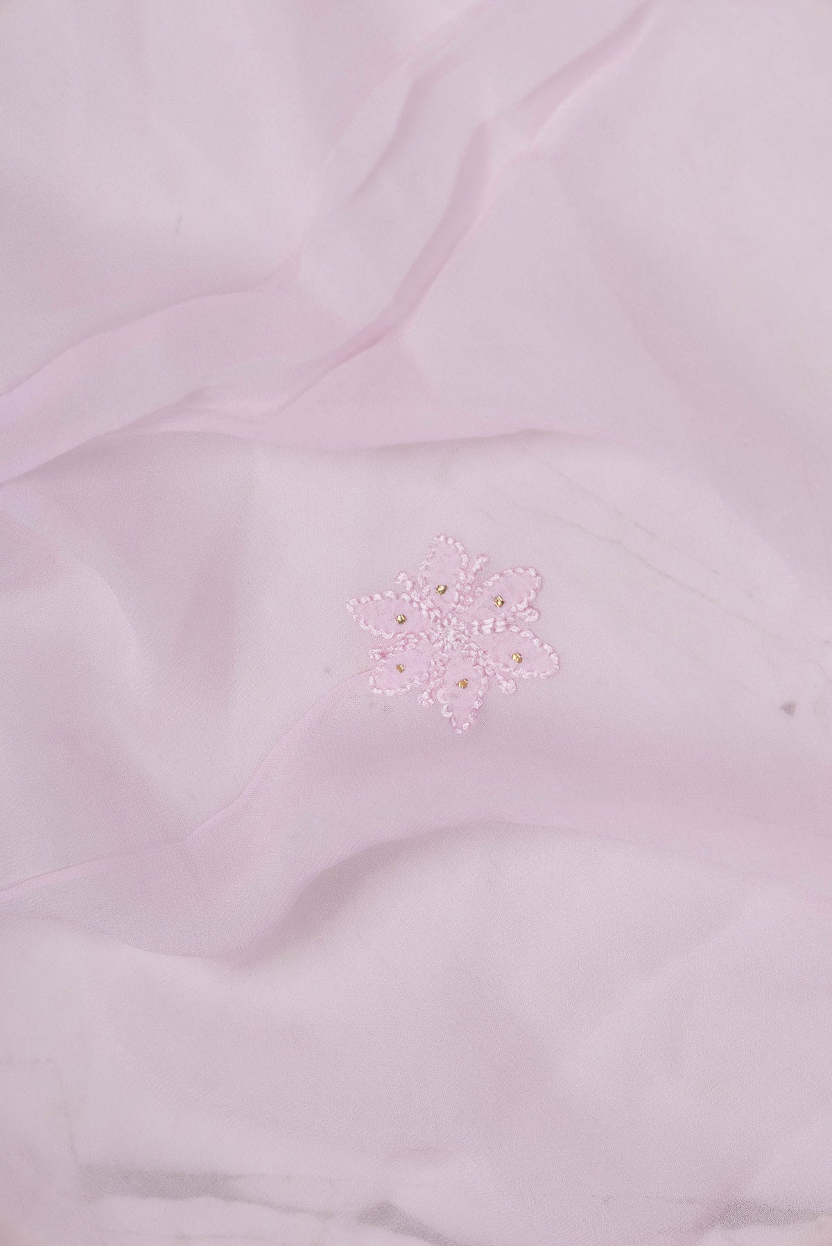 Close up of Pink Dual Tone Georgette Saree with Embroidery on the body and Embroidery Border displaying folds