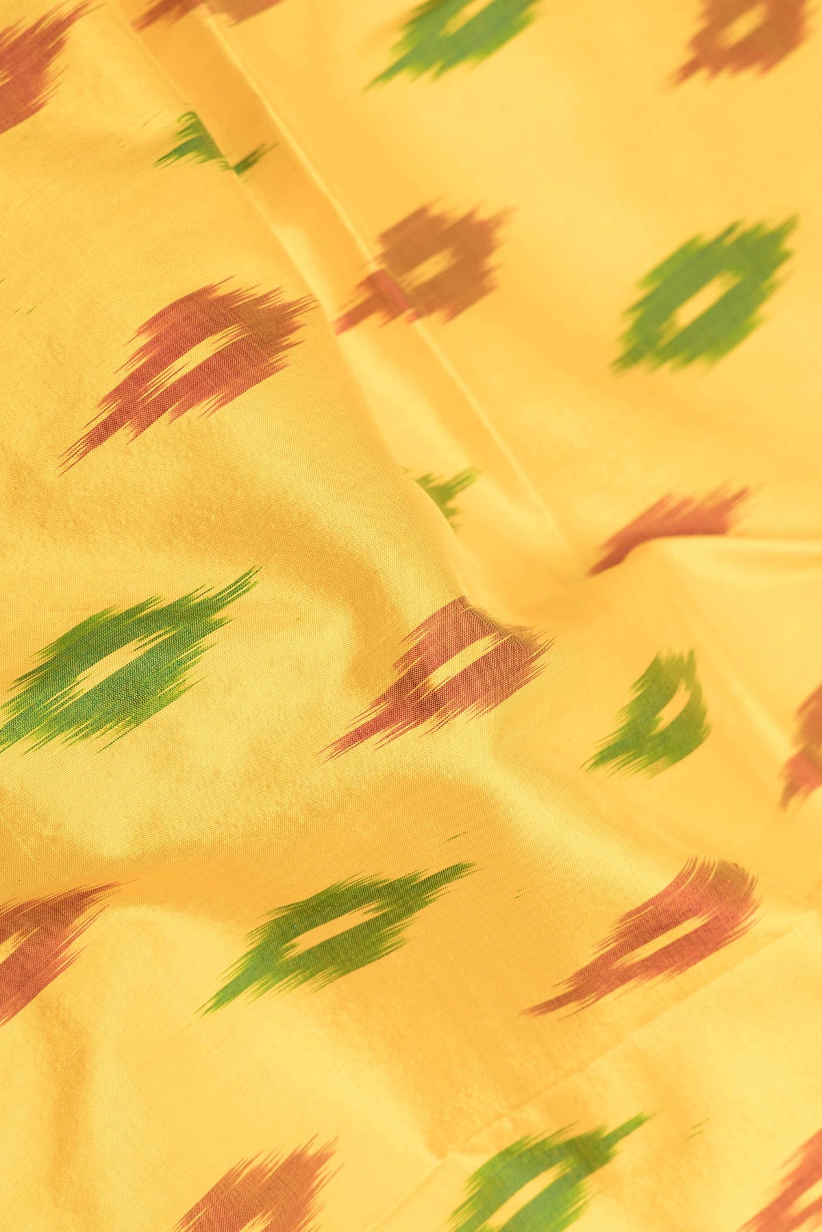 Close up of Yellow Dual Tone Double Ikat Saree with Ikat Print on the body and Zari Border displaying folds