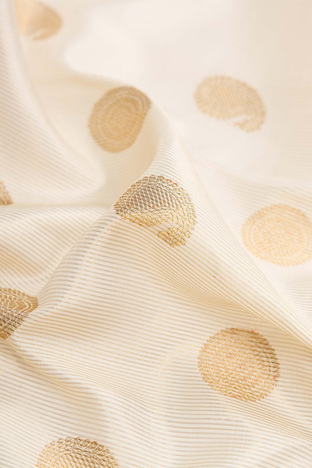 Close up of Pure Silk Pure Zari Off White Dual Tone Kanchipuram Saree with Zari Butta on the body and Zari Border displaying folds