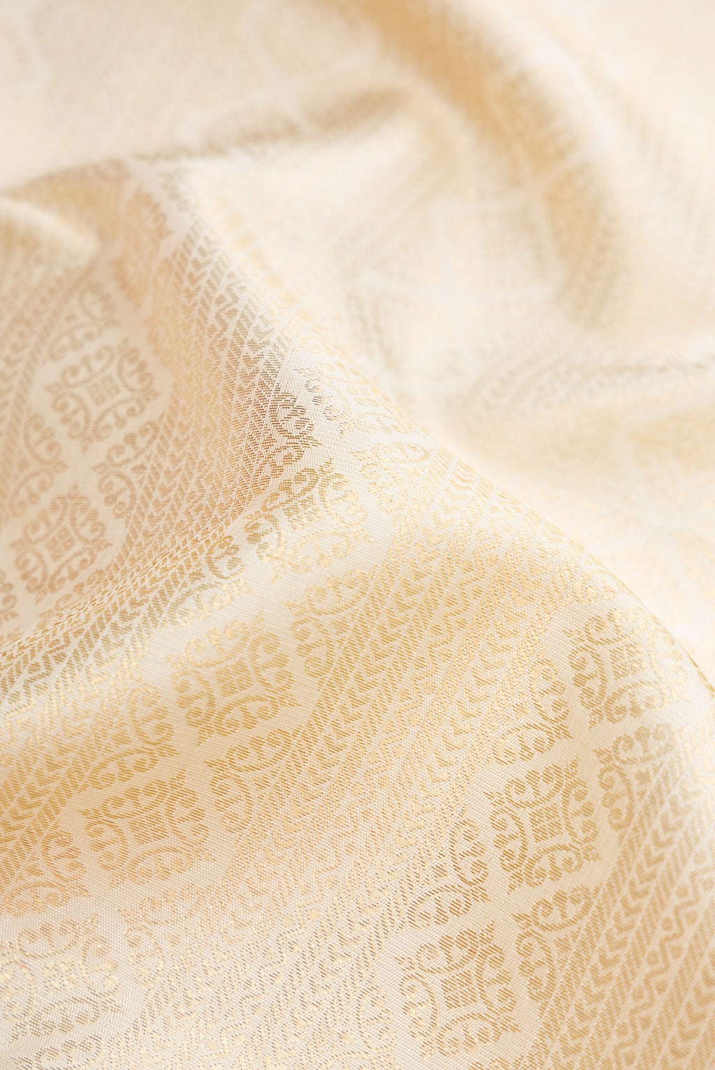 Close up of Pure Silk Pure Zari Off White Dual Tone Kanjivaram Saree with Zari Brocade on the body and Zari Border.  displaying folds