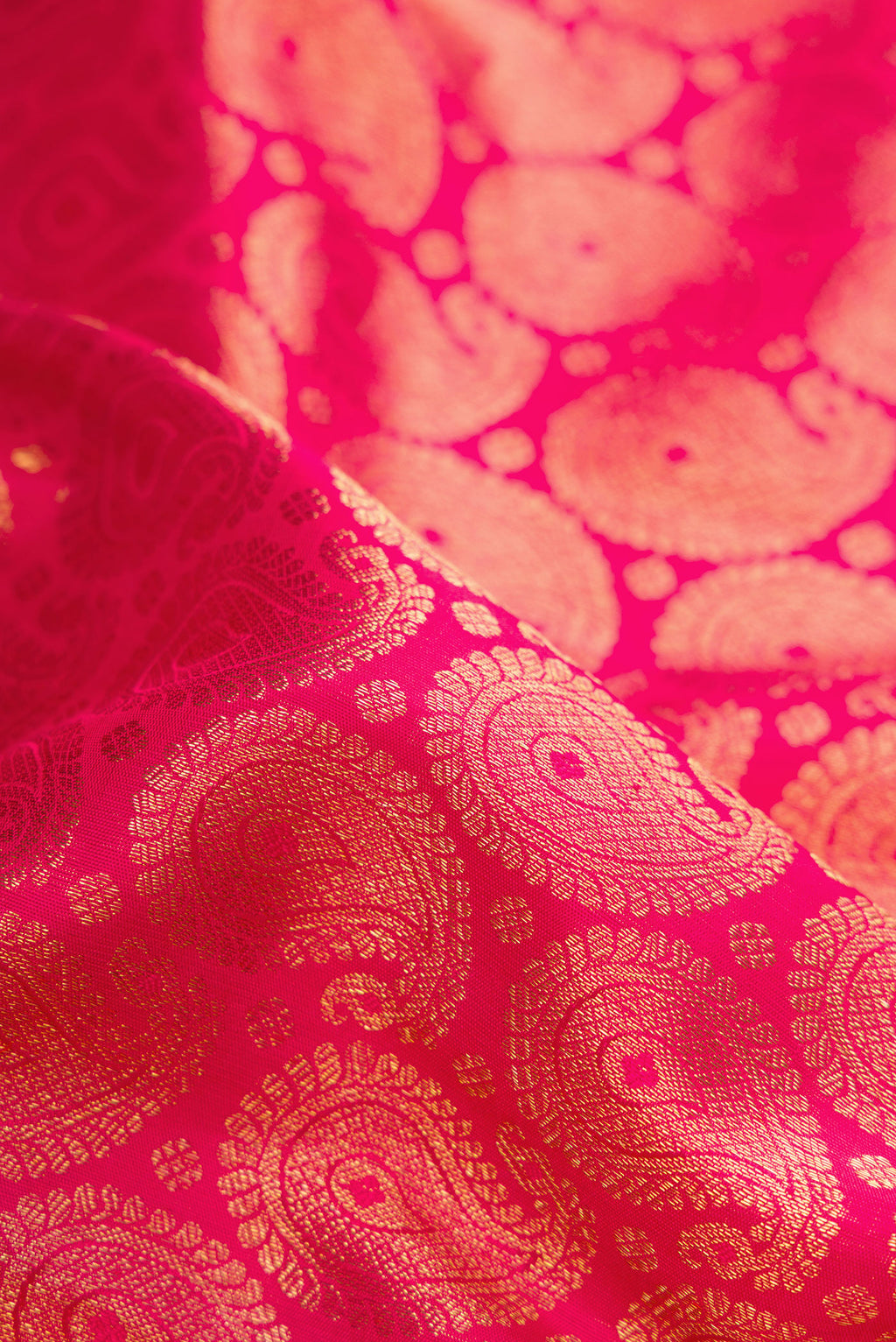 Close up of Pure Silk Pure Zari Pink Dual Tone Kanjivaram Saree with Zari Brocade on the body and Zari Border.  displaying folds