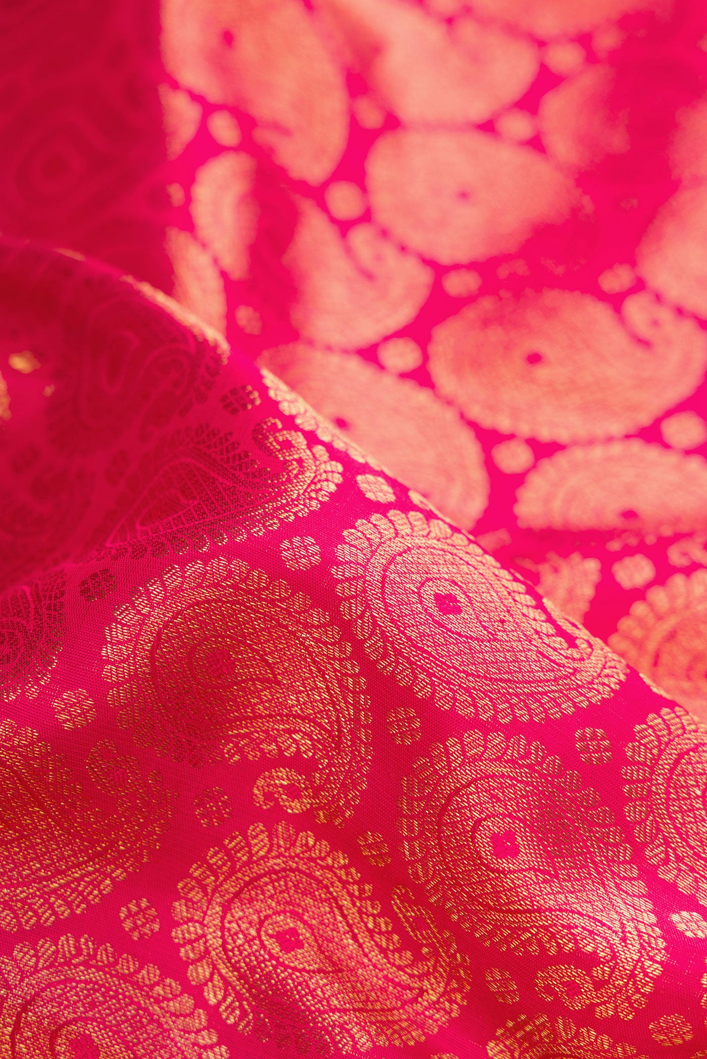 Close up of Pure Silk Pure Zari Pink Dual Tone Kanjivaram Saree with Zari Brocade on the body and Zari Border.  displaying folds