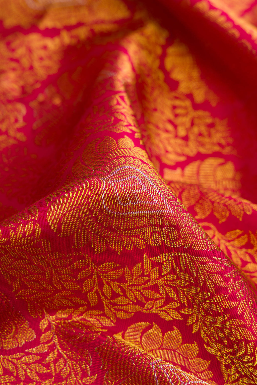 Close up of Maroon Dual Tone Kanjivaram Silk Saree with Zari Brocade on the body and Zari Border.  displaying folds