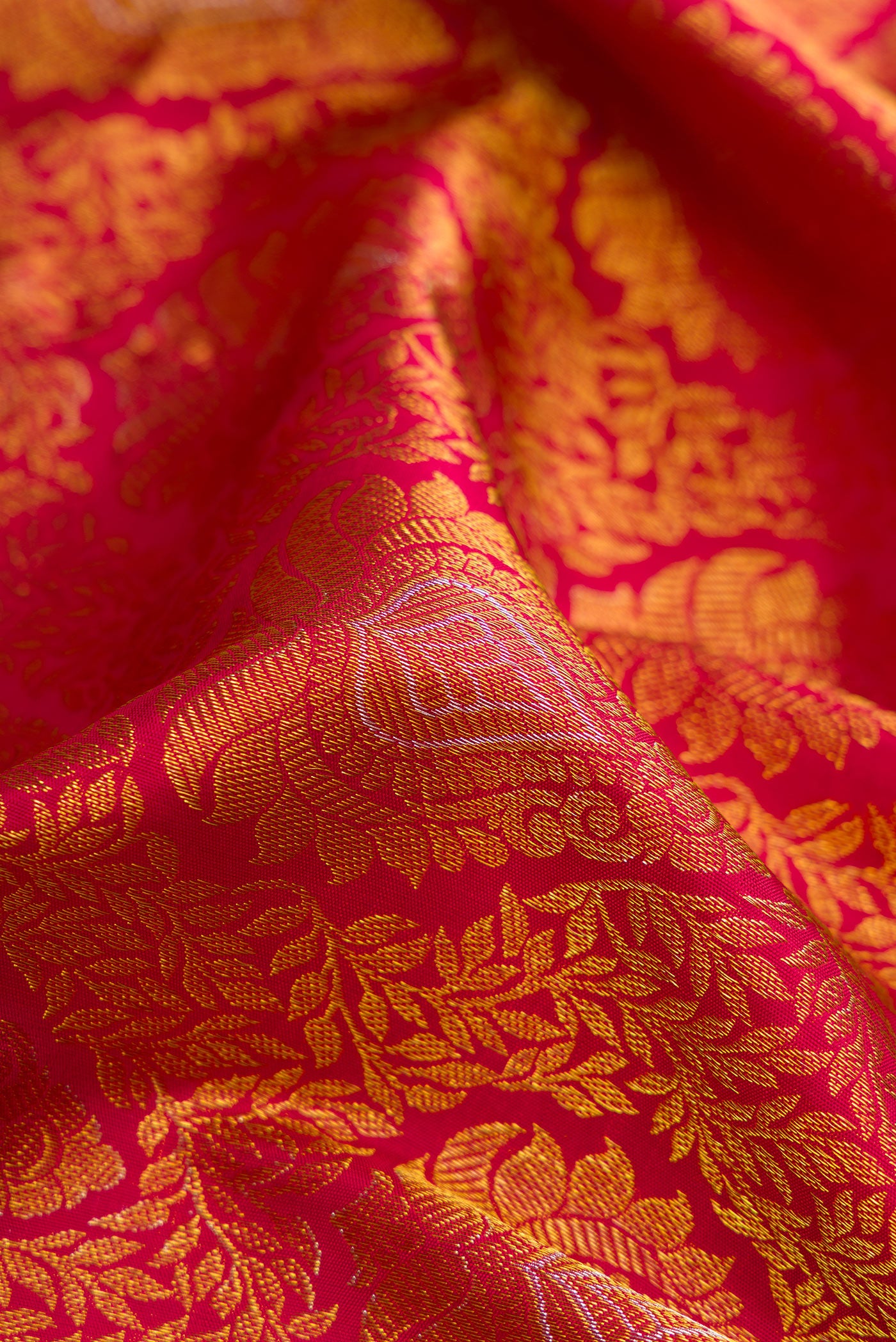 Close up of Maroon Dual Tone Kanjivaram Silk Saree with Zari Brocade on the body and Zari Border.  displaying folds
