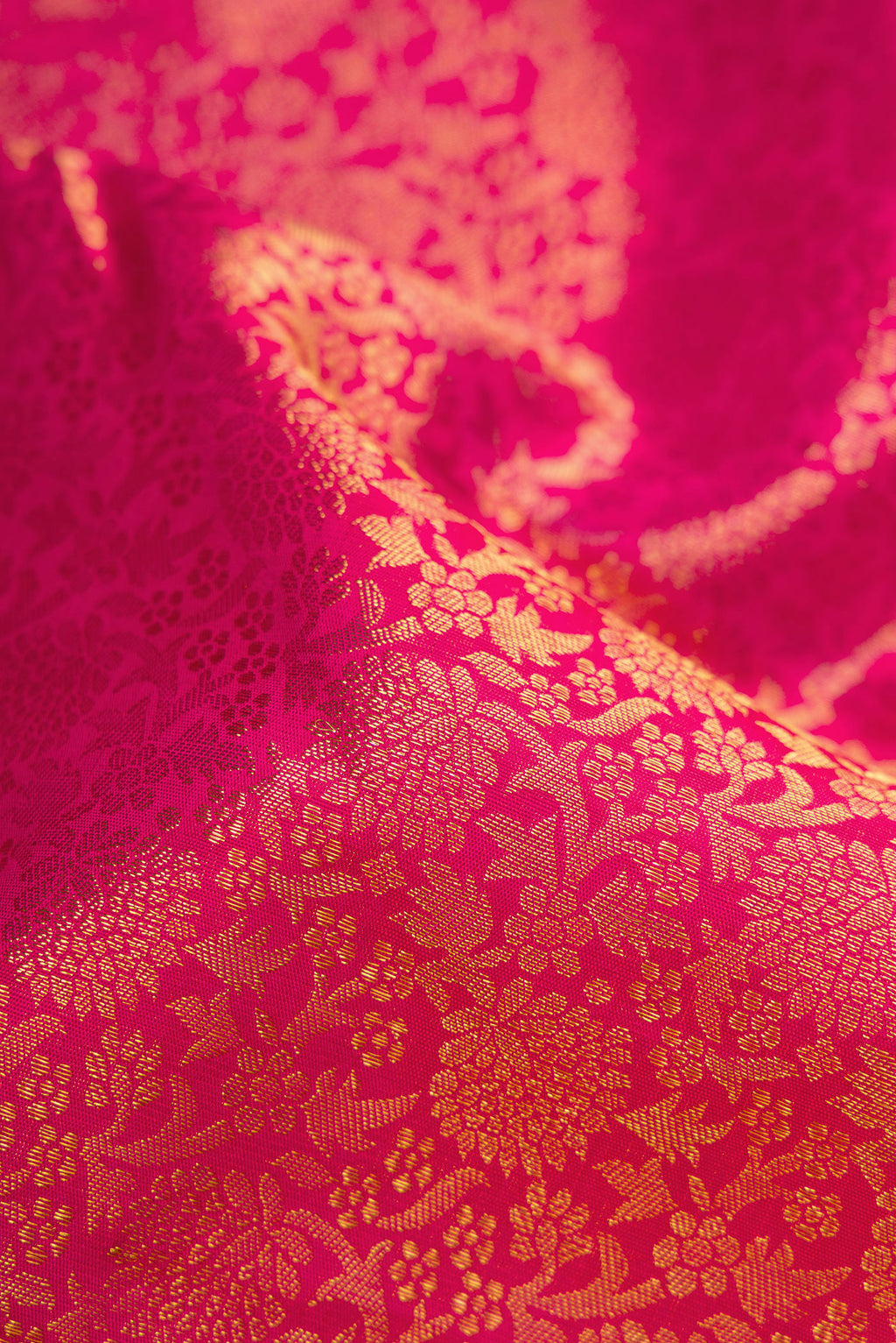 Close up of Pure Silk Pure Zari Magenta Dual Tone Kanjivaram Saree with Zari Brocade on the body and Zari Border.  displaying folds