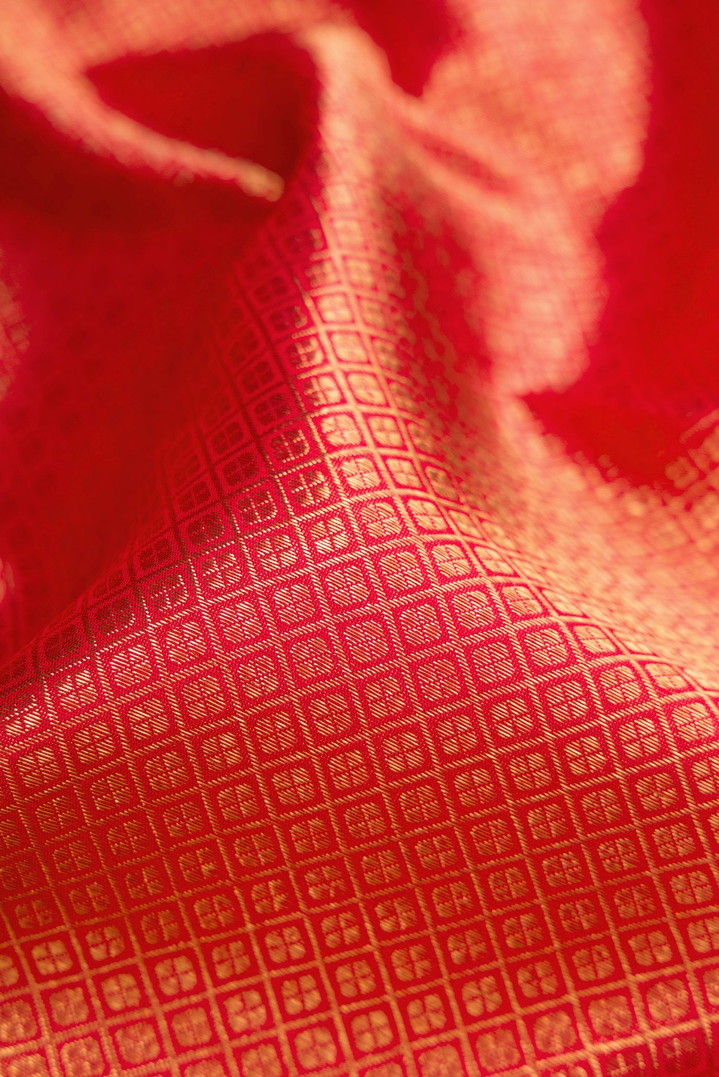 Close up of Pure Silk Pure Zari Red Dual Tone Kanjivaram Saree with Zari Brocade on the body and Zari Border.  displaying folds