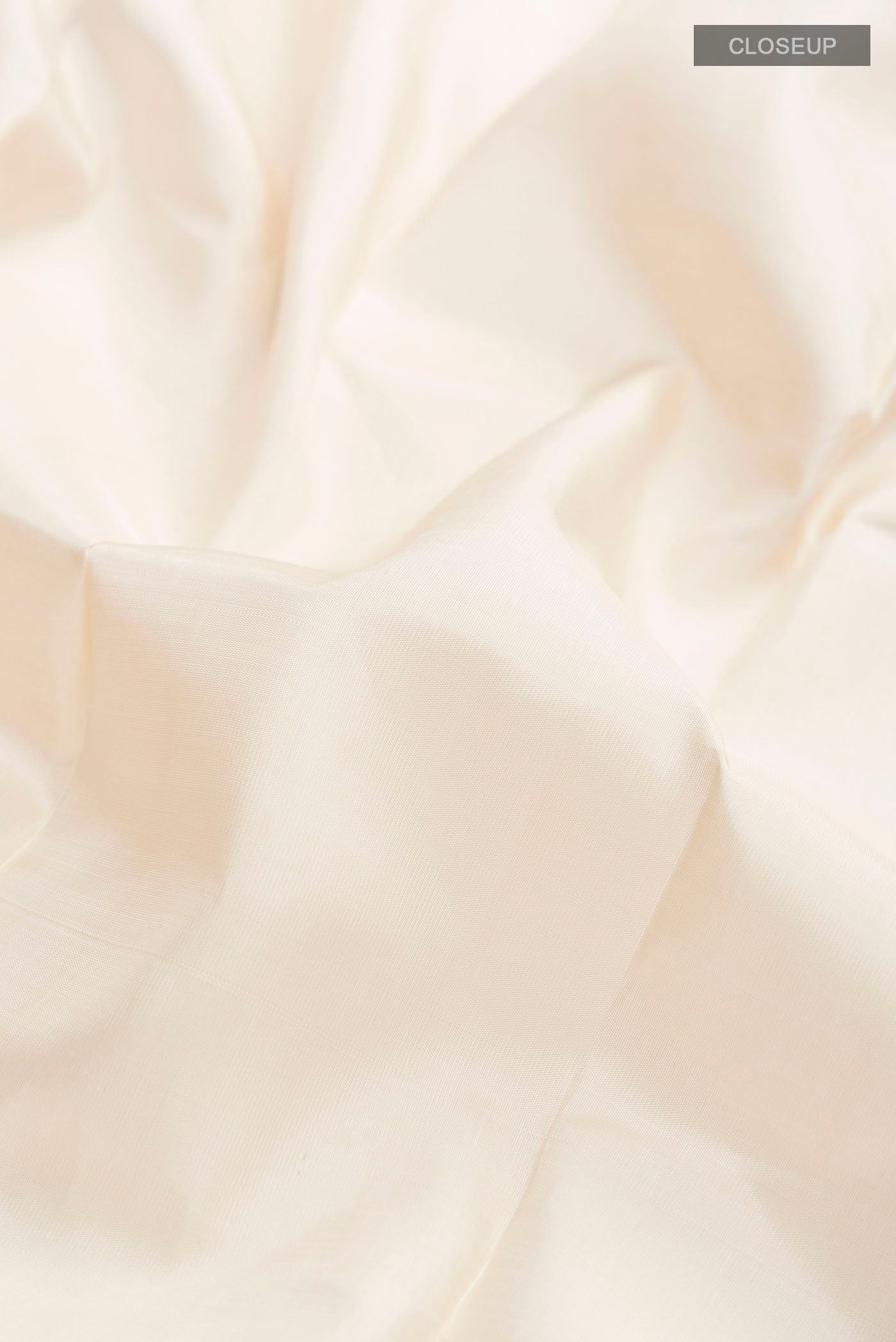 Close up of Cream Kanchipuram Silk Saree with Plain Body and Temple Border displaying folds