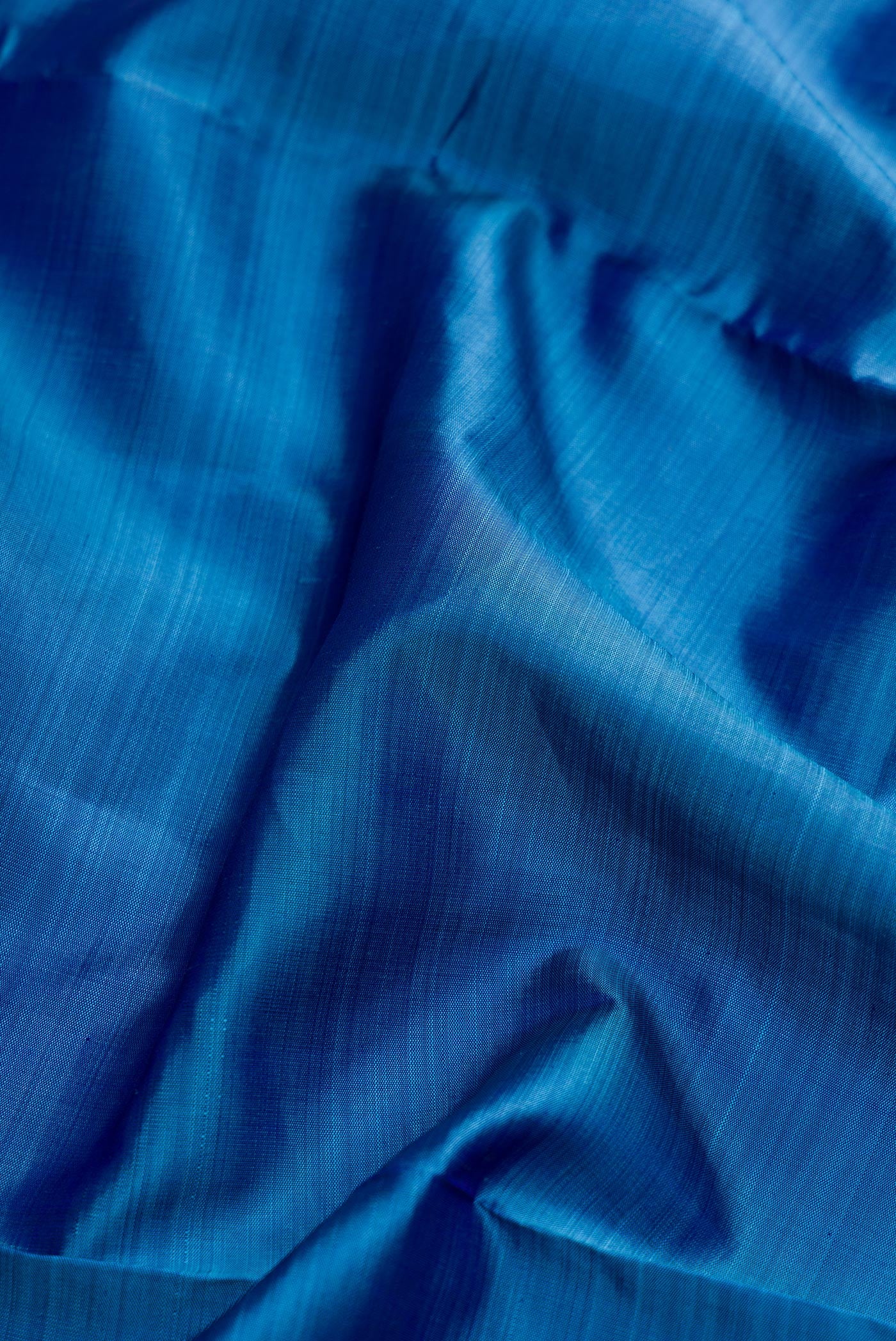 Close up of Pure Silk Pure Zari Peacock Blue Dual Tone Kanchipuram Nine Yards Saree with Plain Body and Zari Border.  displaying folds