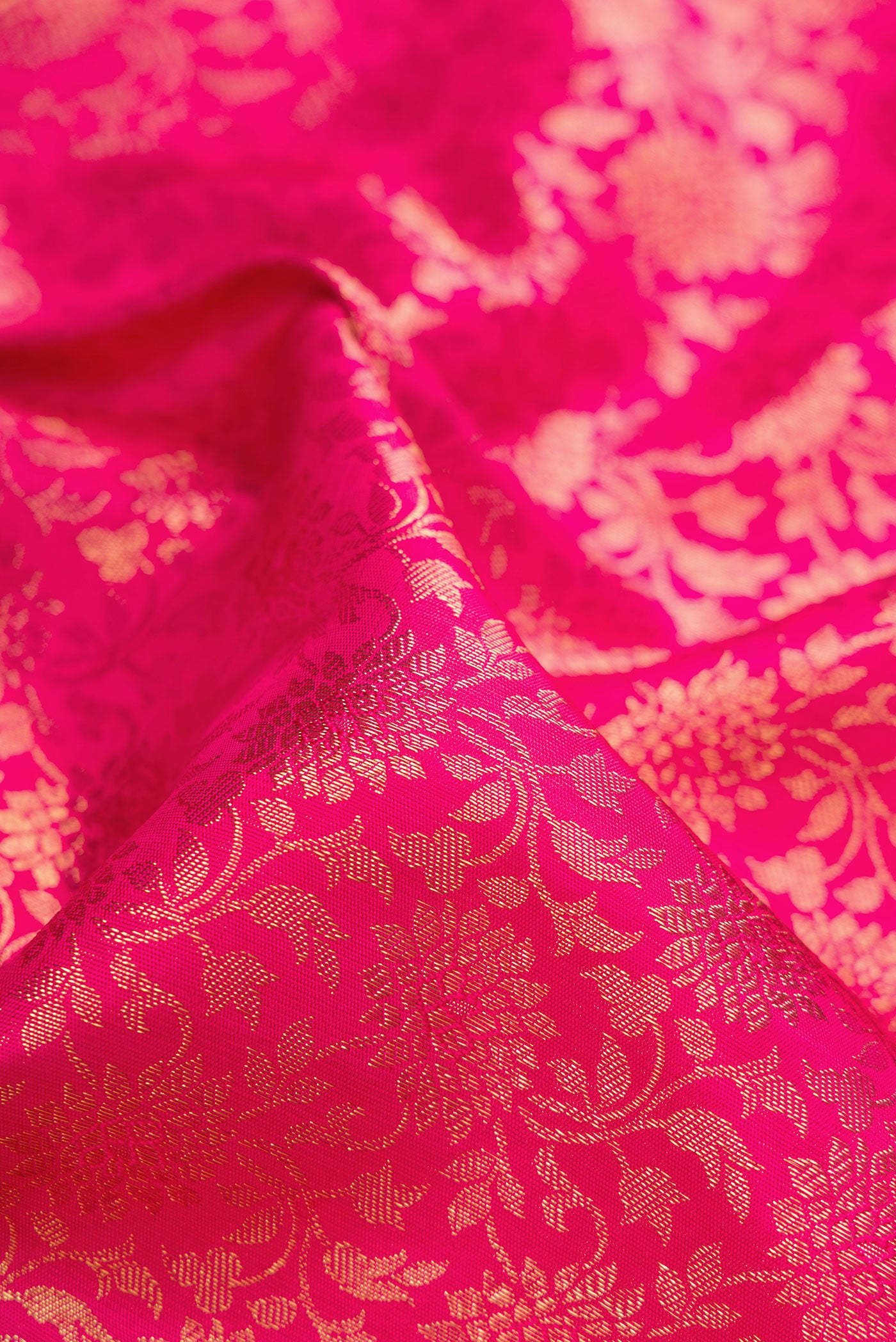 Close up of Pure Silk Pure Zari Dark Pink Dual Tone Kanjivaram Saree with Zari Brocade on the body and Zari Border.  displaying folds