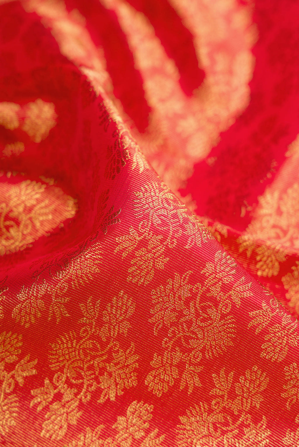 Close up of Pure Silk Pure Zari Red Dual Tone Kanjivaram Saree with Zari Brocade on the body and Zari Border.  displaying folds