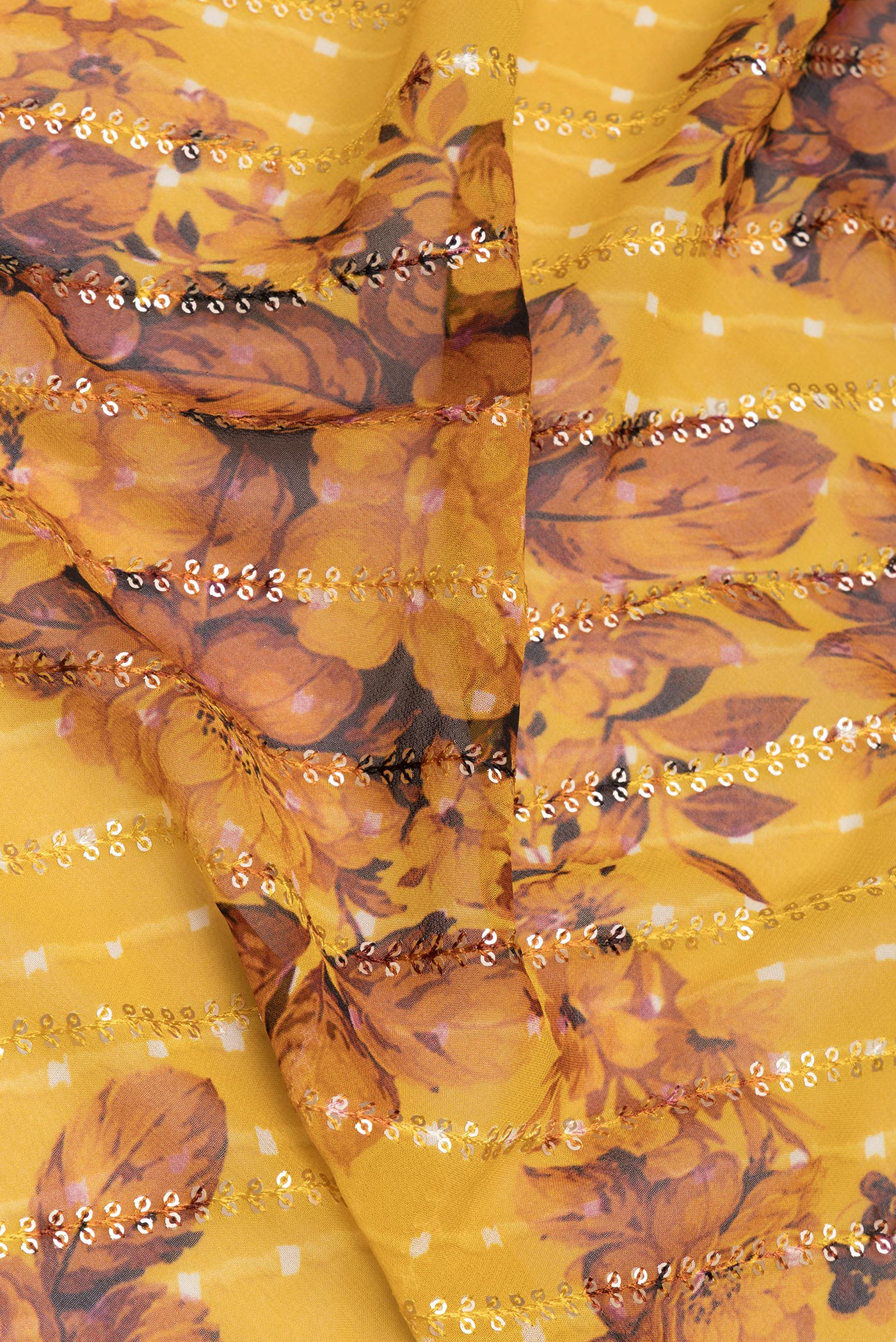 Close up of Mustard Georgette Saree with Embroidery on the body and Sequin Border.  displaying folds