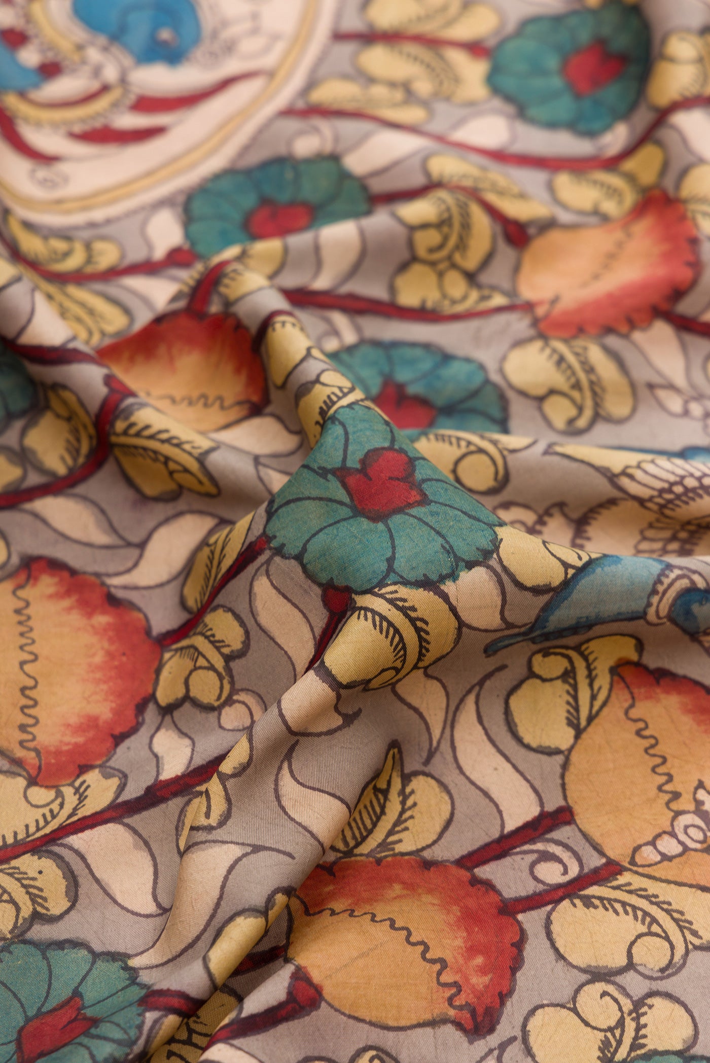 Close up of Beige Dual Tone Kanchipuram Silk Saree with kalamkari Print on the body and Zari Border.  displaying folds