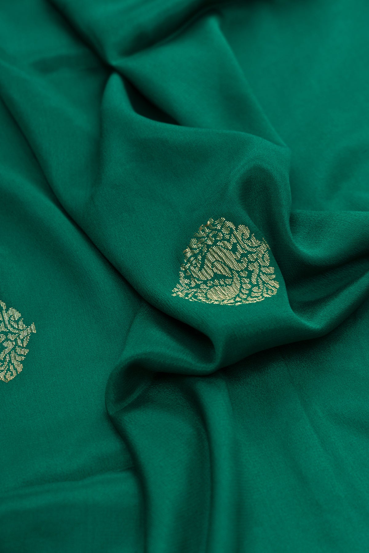 Close up of Bottle Green Dual Tone Mysore Georgette Saree with Zari Butta on the body and Zari Border.  displaying folds