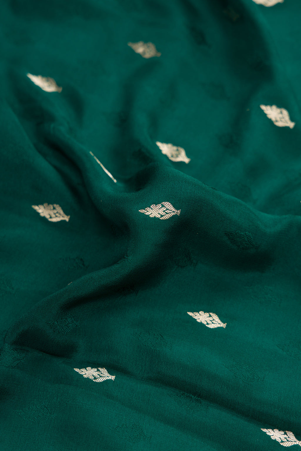 Close up of Bottle Green Dual Tone Mysore Georgette Saree with Zari Butta on the body and Zari Border.  displaying folds