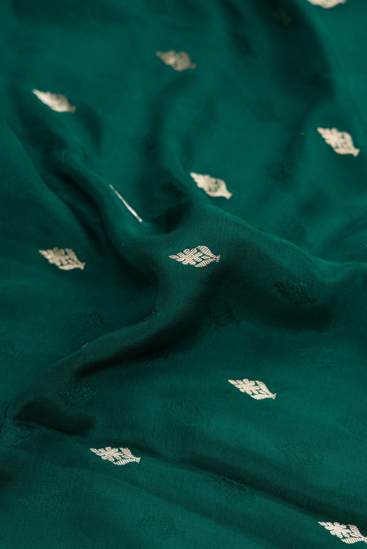 Close up of Bottle Green Dual Tone Mysore Georgette Saree with Zari Butta on the body and Zari Border.  displaying folds
