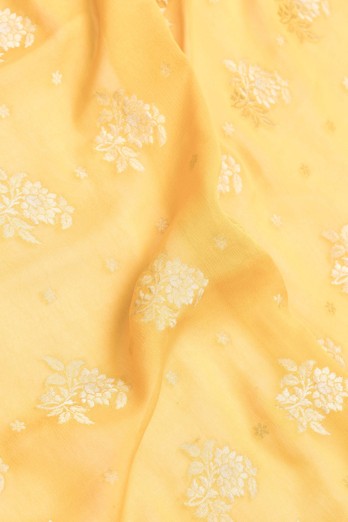 Close up of Mustard Dual Tone Mysore Georgette Saree with Zari Butta on the body and Zari Border.  displaying folds