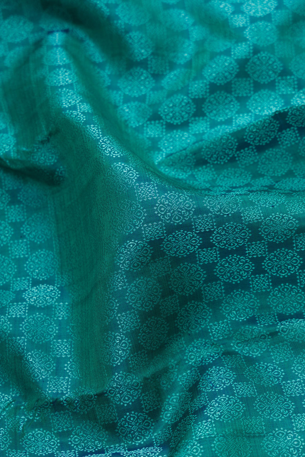 Close up of Peacock Blue Dual Tone Kanjivaram Silk Saree with Jacquard design on the body and Zari Border.  displaying folds