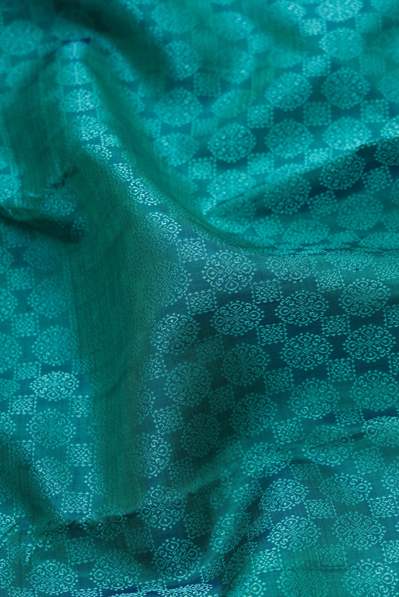 Close up of Peacock Blue Dual Tone Kanjivaram Silk Saree with Jacquard design on the body and Zari Border.  displaying folds