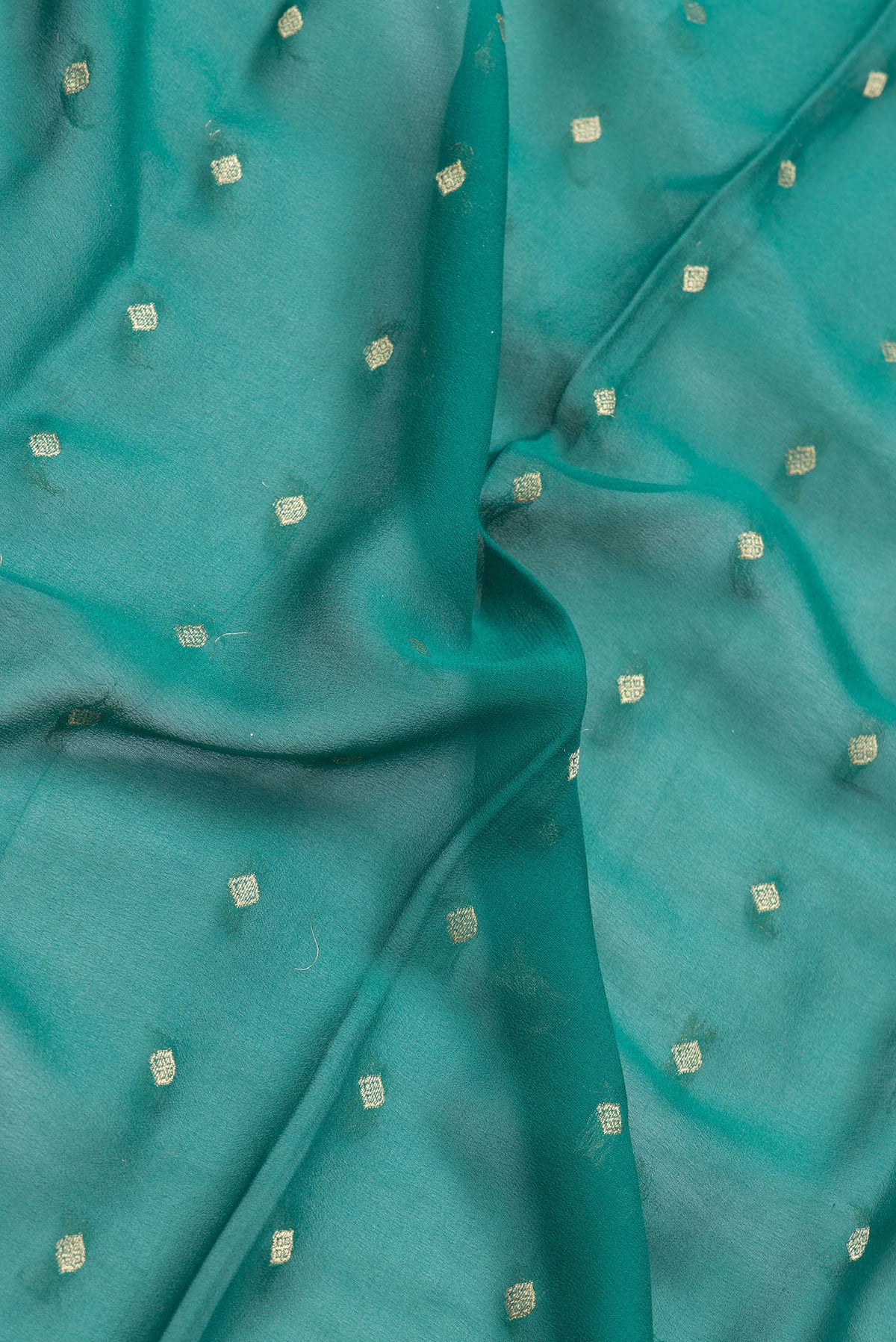 Close up of Green Dual Tone Mysore Georgette Saree with Zari Butta on the body and Fancy Border.  displaying folds