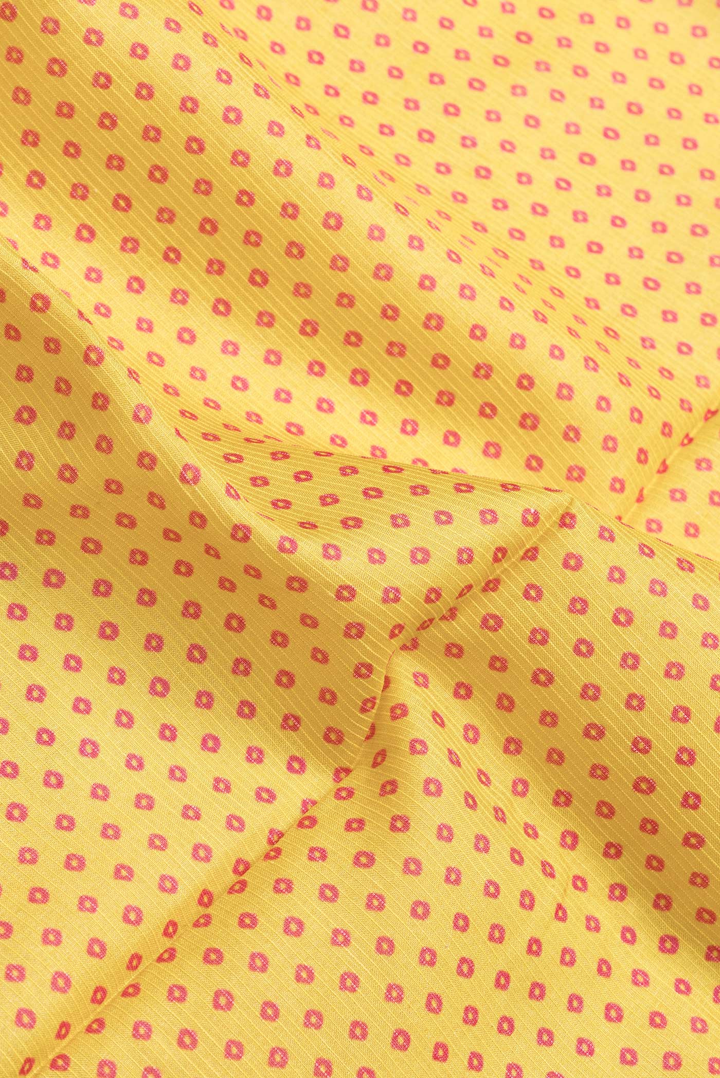 Close up of Yellow Dual Tone Tussar Silk Saree with Bandhani Print on the body and Zari Border.  displaying folds