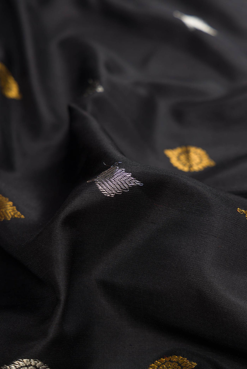Close up of Black Dual Tone Gadwal Silk Saree with Zari Butta on the body and Zari Border displaying folds