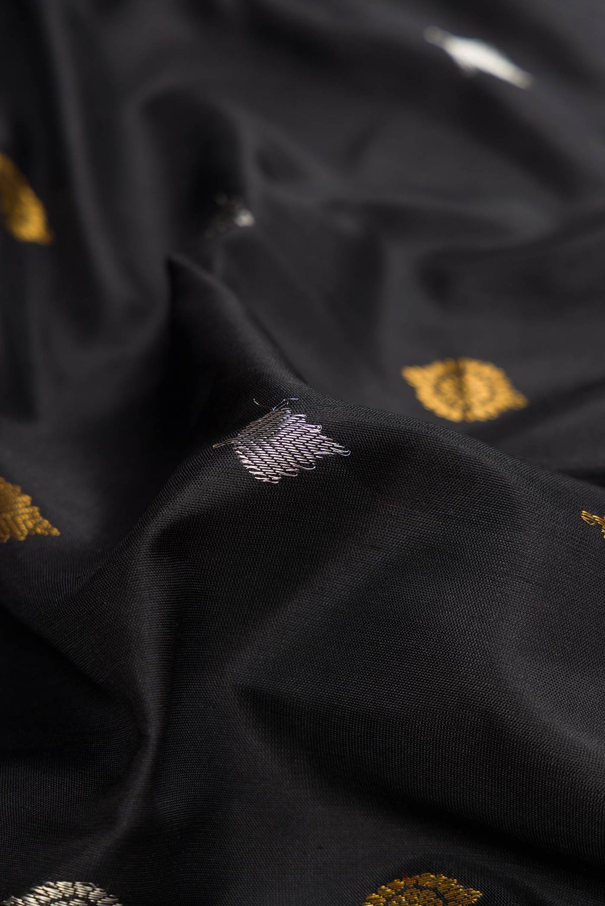 Close up of Black Dual Tone Gadwal Silk Saree with Zari Butta on the body and Zari Border displaying folds