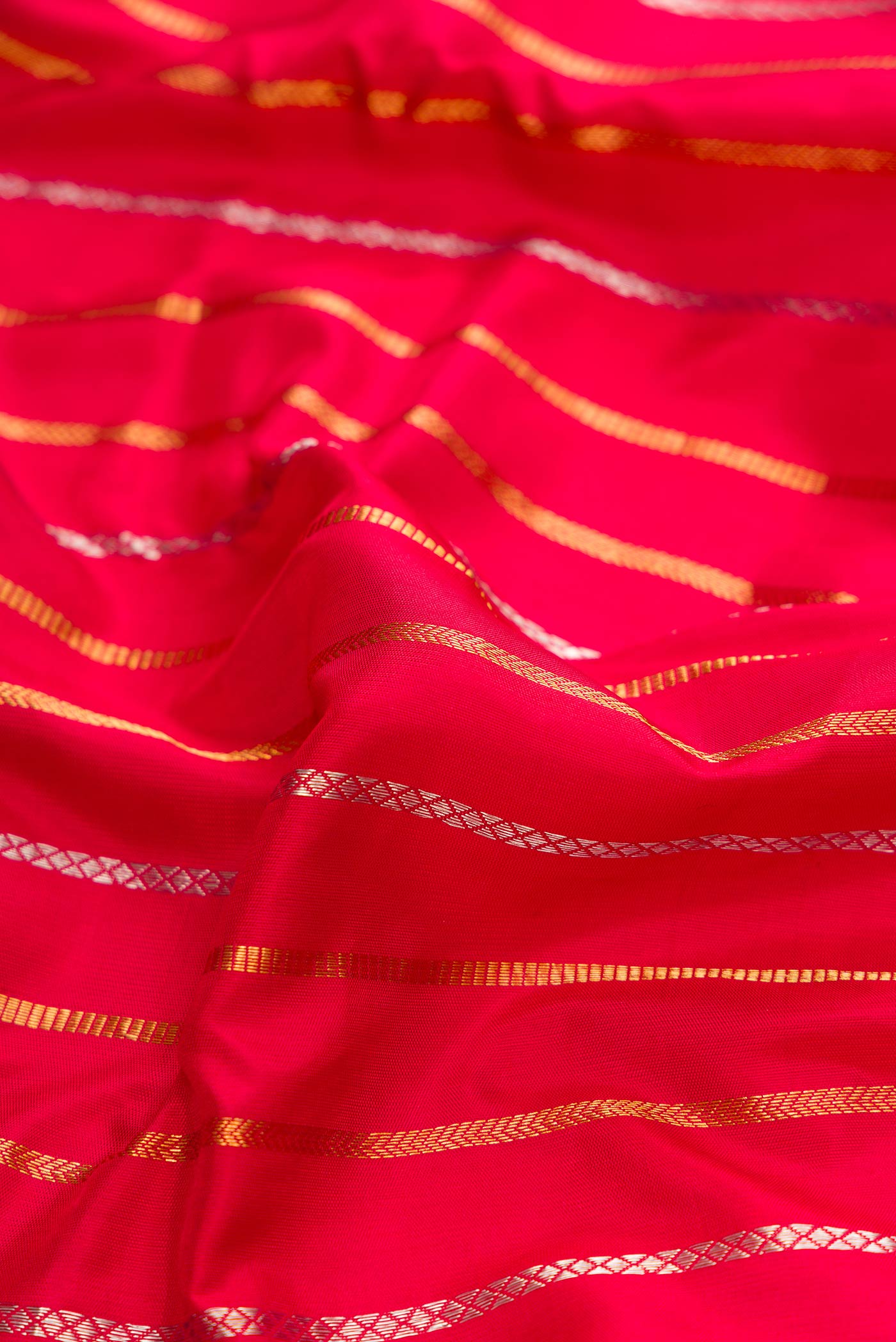 Close up of Deep Red Dual Tone Gadwal Silk Saree with Stripes on the body and Fancy Border displaying folds