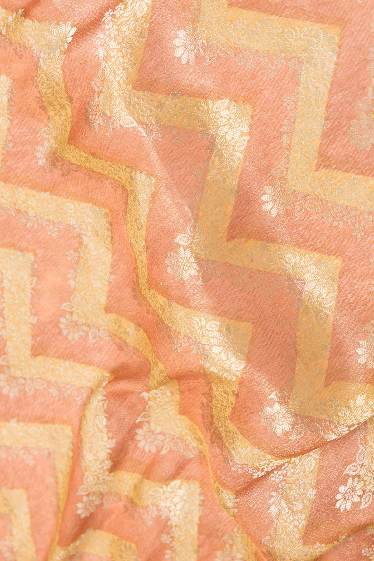 Close up of Golden Peach Dual Tone Mysore Georgette Saree with Zari Butta on the body and Zari Border displaying folds