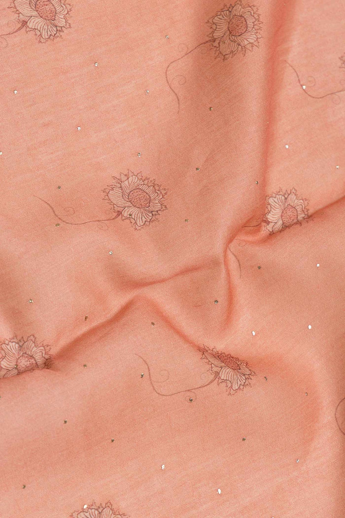 Close up of Peach Dual Tone Tussar Silk Saree with Printed design on the body and Zari Border.  displaying folds
