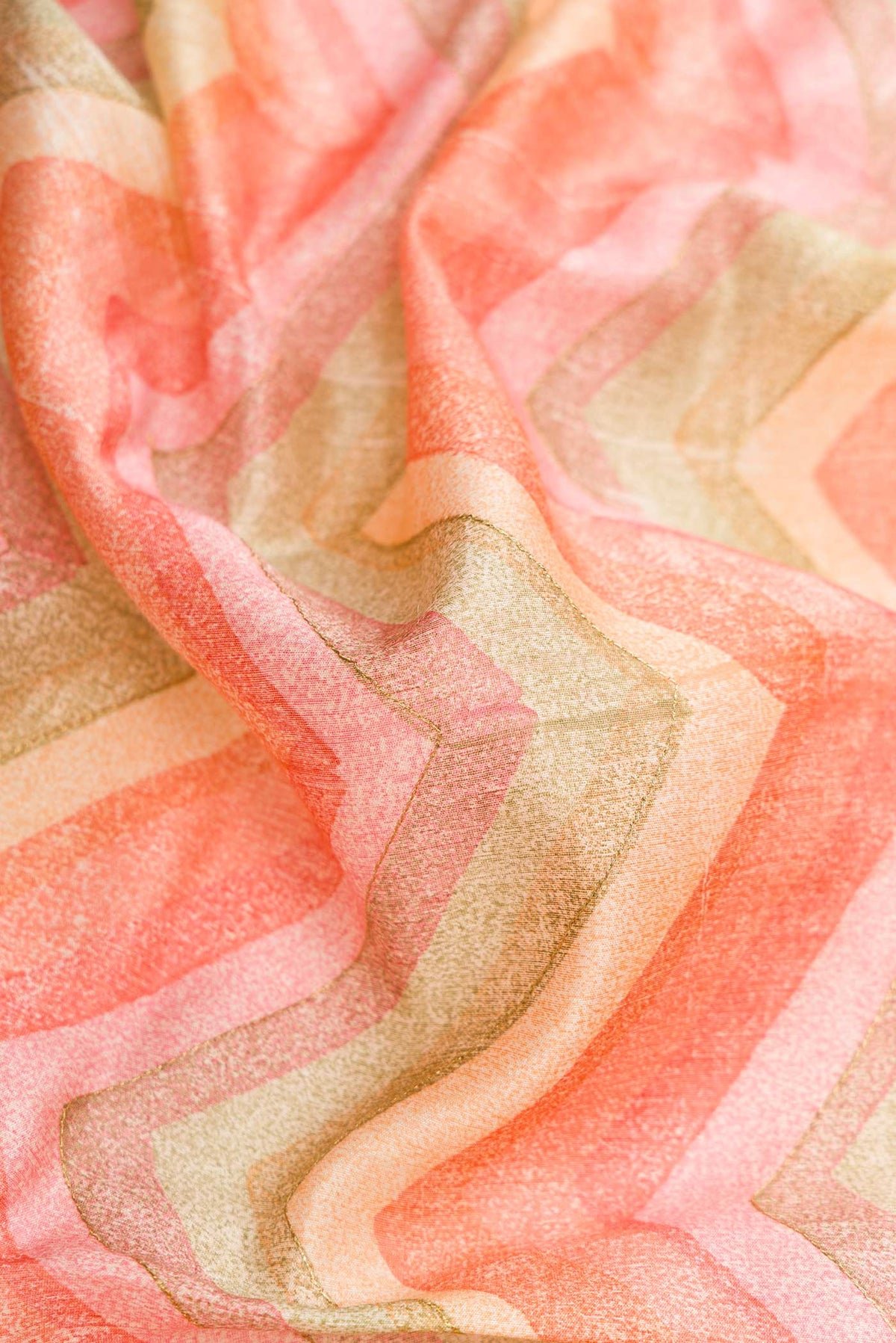 Close up of Peach Dual Tone Tussar Silk Saree with Printed design on the body and Zari Border.  displaying folds