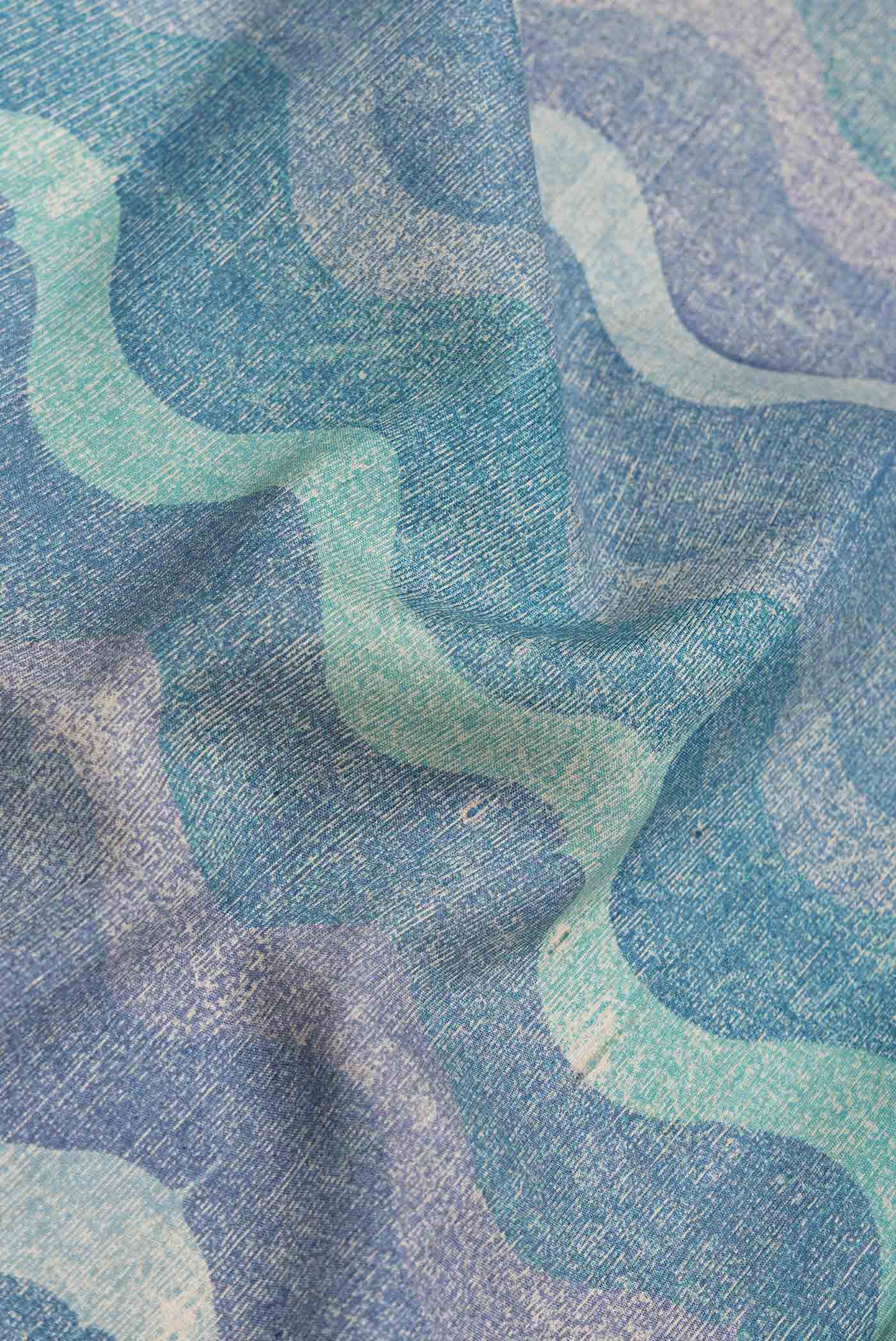 Close up of Blue and Grey Color Tussar Silk Saree with Printed design on the body and Zari Border.  displaying folds