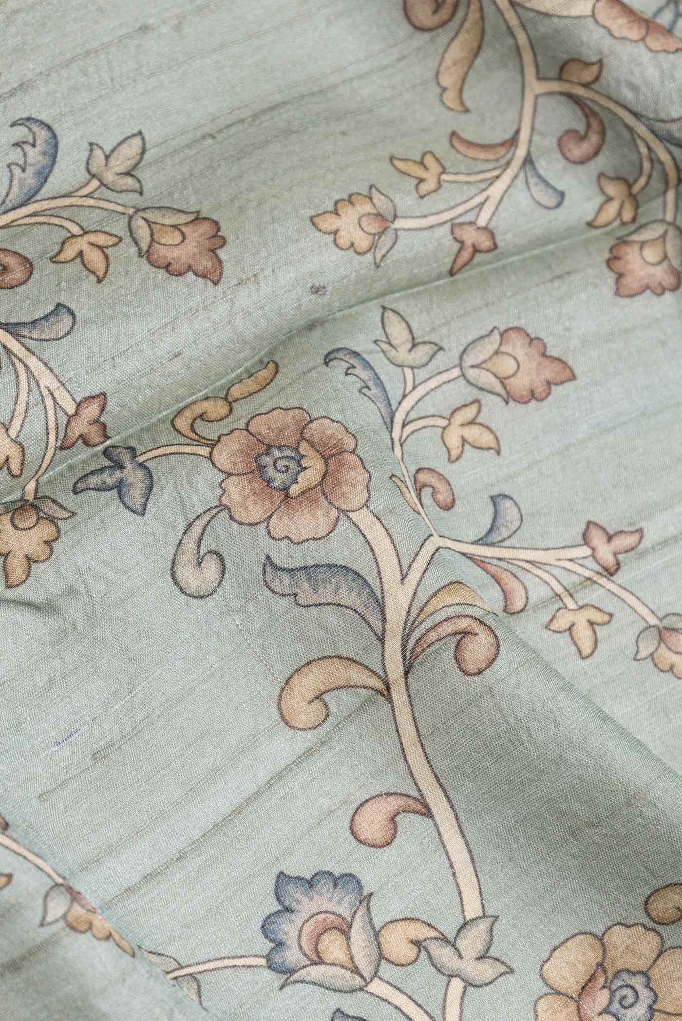 Close up of Grey Dual Tone Tussar Silk Saree with Printed design on the body and Embroidery Border displaying folds