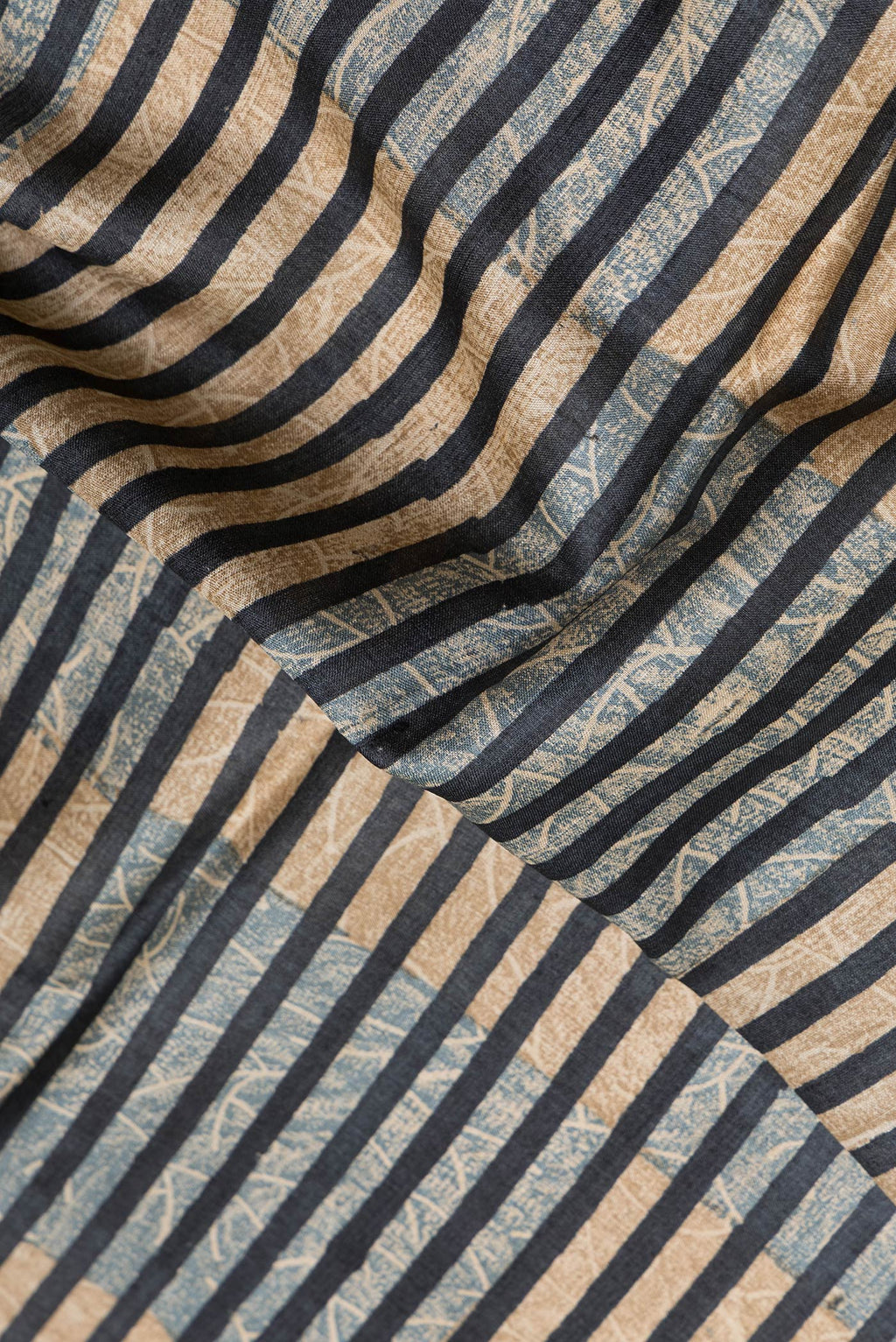 Close up of Black Dual Tone Tussar Silk Saree with Printed design on the body and Printed Border.  displaying folds