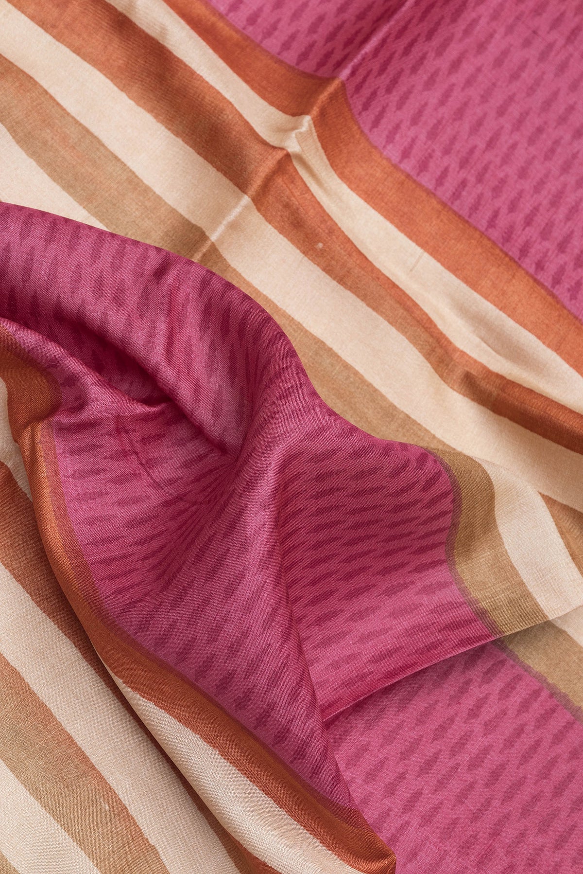 Close up of Pink Tussar Silk Saree with Stripes on the body and Printed Border.  displaying folds