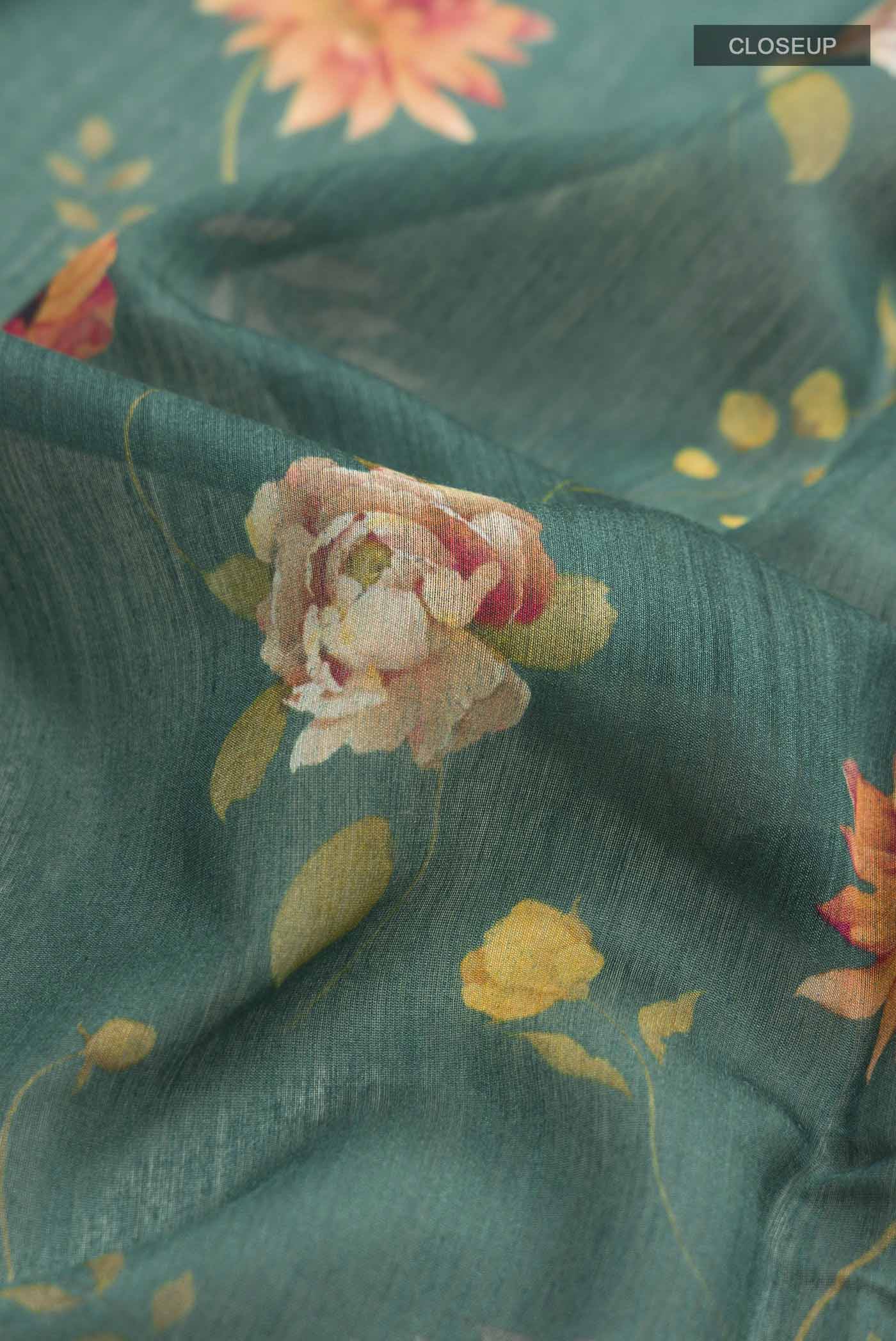Close up of Green Tussar Silk Saree with Printed design on the body and Zari Border displaying folds