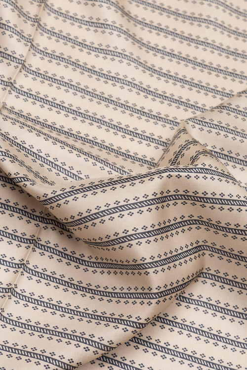 Close up of Beige Dual Tone Kanchipuram Silk Saree with Printed design on the body and Zari Border.  displaying folds