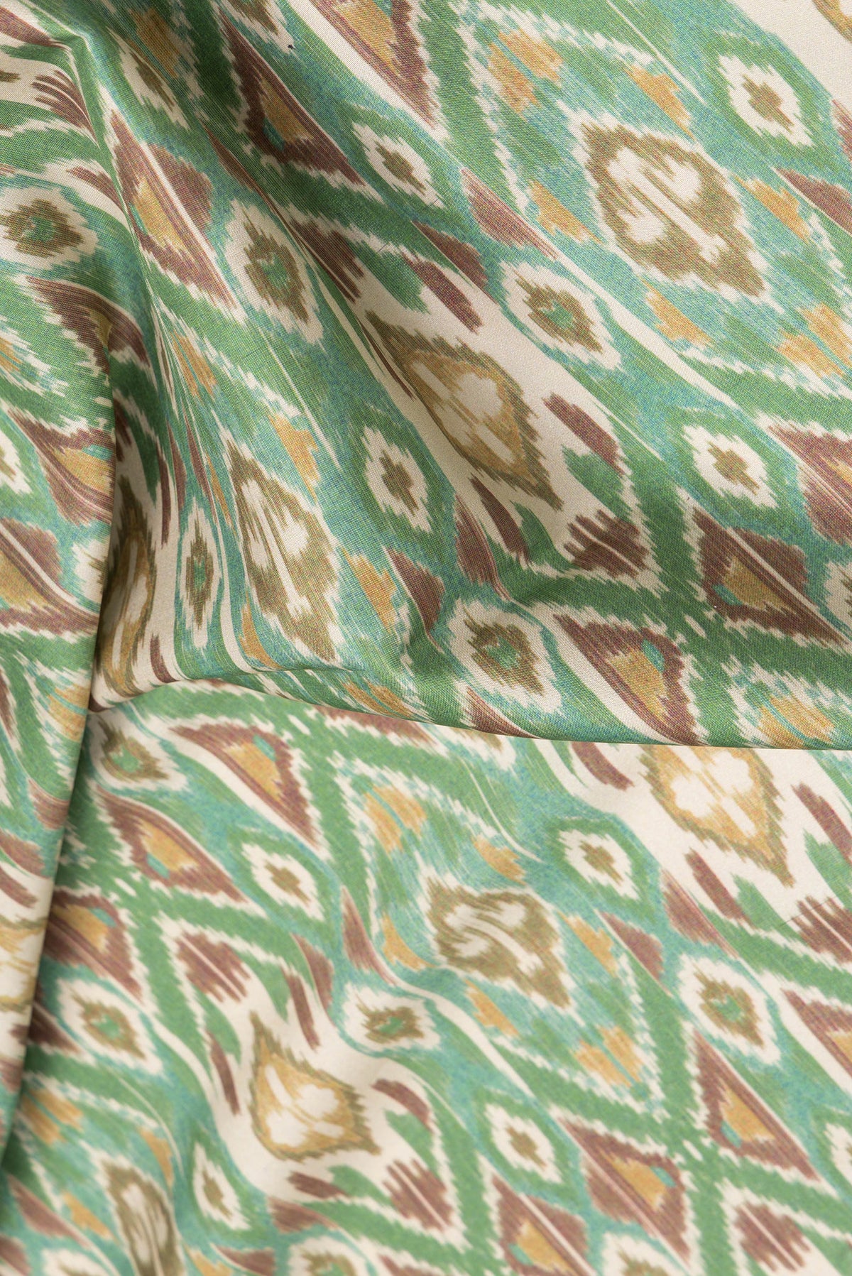Close up of Green Dual Tone Paithani Silk Saree with Ikat Print on the body and Paithani Border.  displaying folds