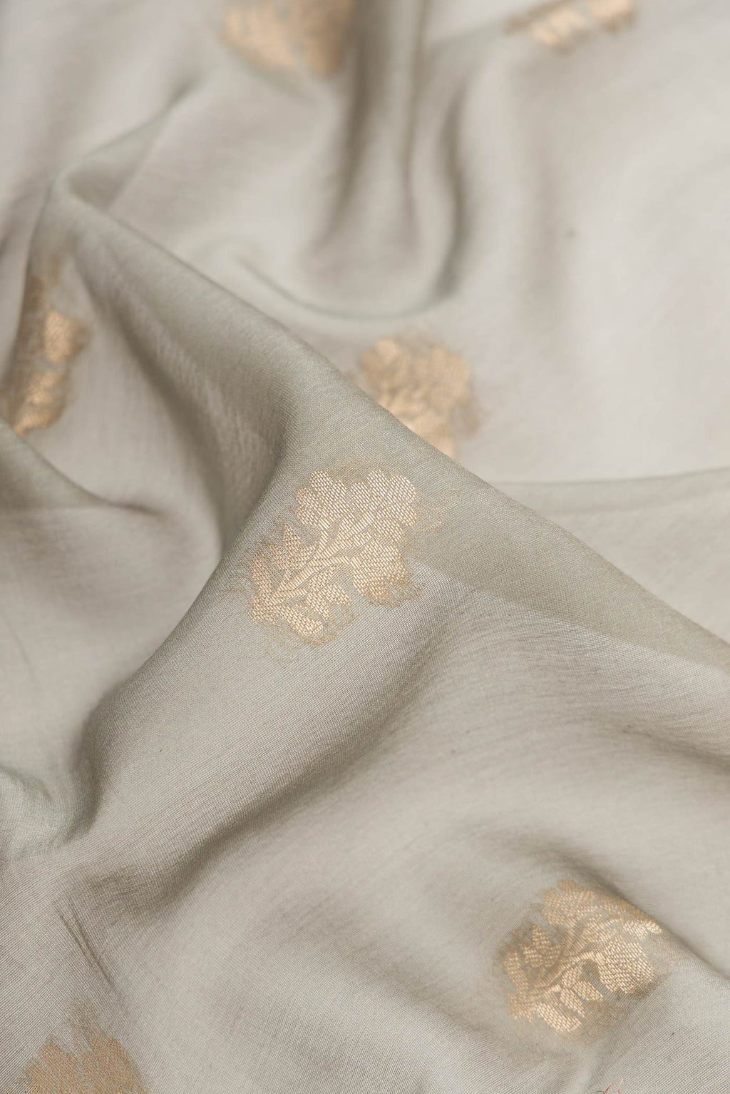 Close up of Olive Green Dual Tone Tussar Silk Saree with Zari Butta on the body and Zari Border.  displaying folds