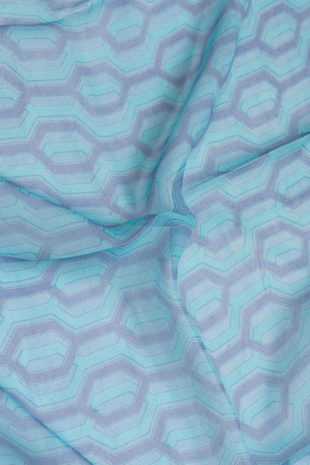 Close up of Sky Blue Dual Tone Mysore Chiffon Saree with Printed design on the body and Plain Border.  displaying folds