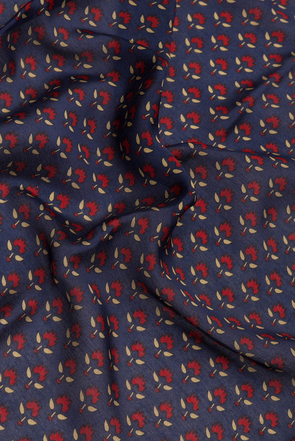 Close up of Navy Blue Crepe Saree with Printed design on the body and Zari Border.  displaying folds