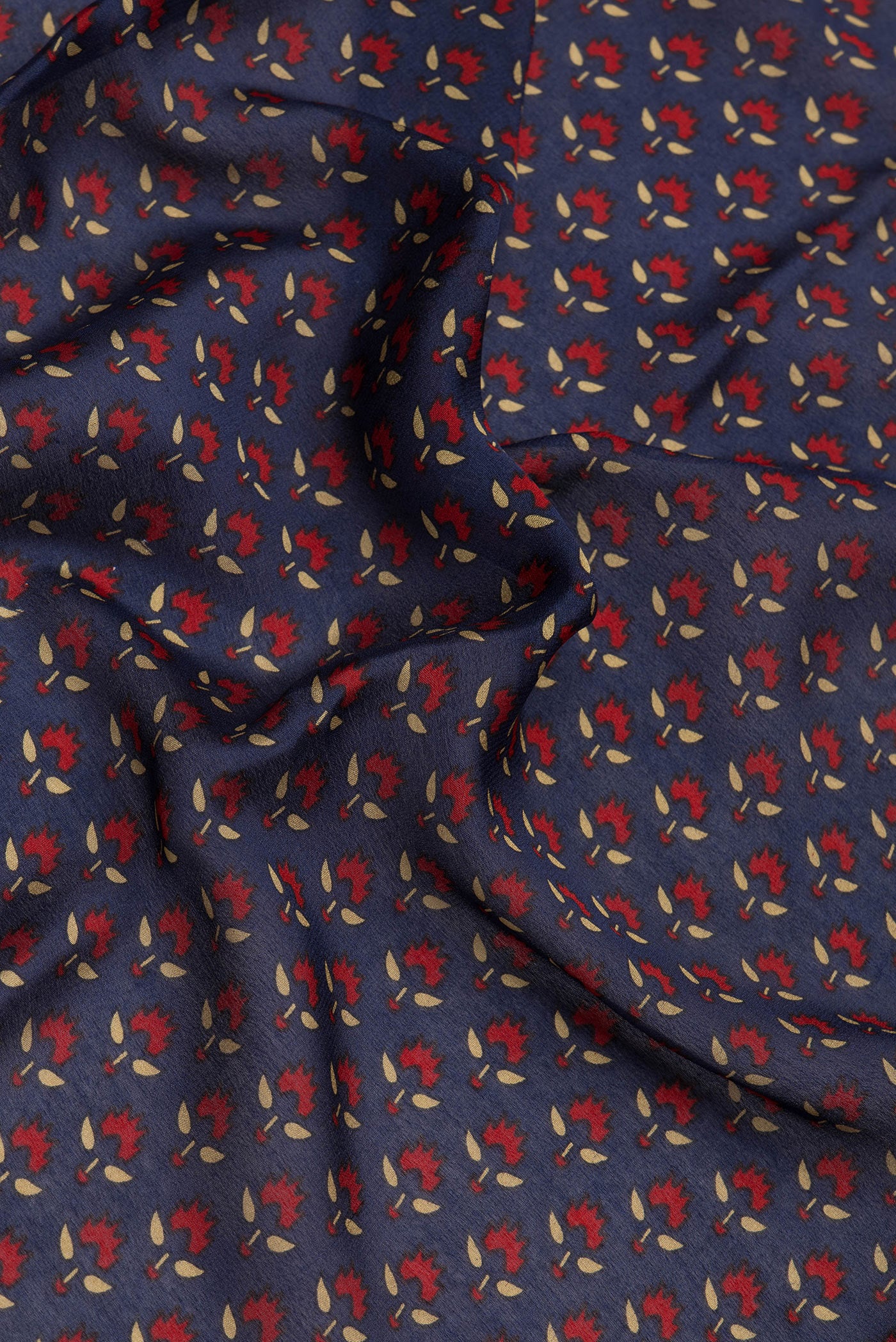 Close up of Navy Blue Crepe Saree with Printed design on the body and Zari Border.  displaying folds