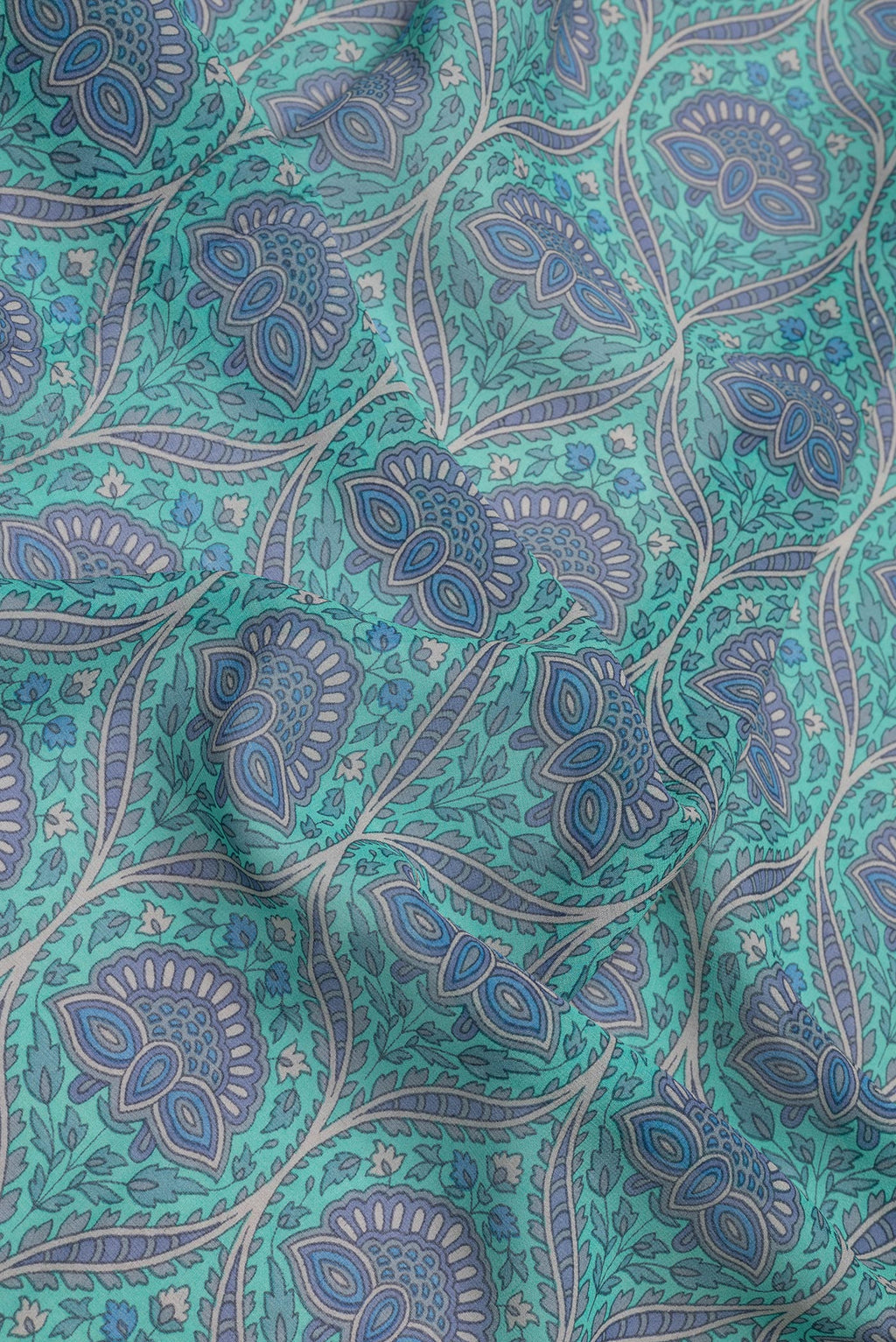 Close up of Sky Blue Dual Tone Mysore Crepe Saree with Printed design on the body and Plain Border.  displaying folds