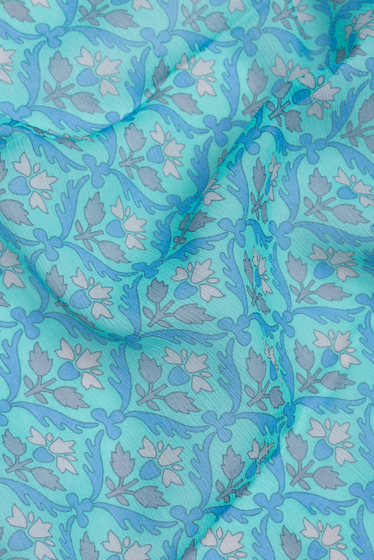 Close up of Sky Blue Mysore Chiffon Saree with Printed design on the body and Thread Border.  displaying folds