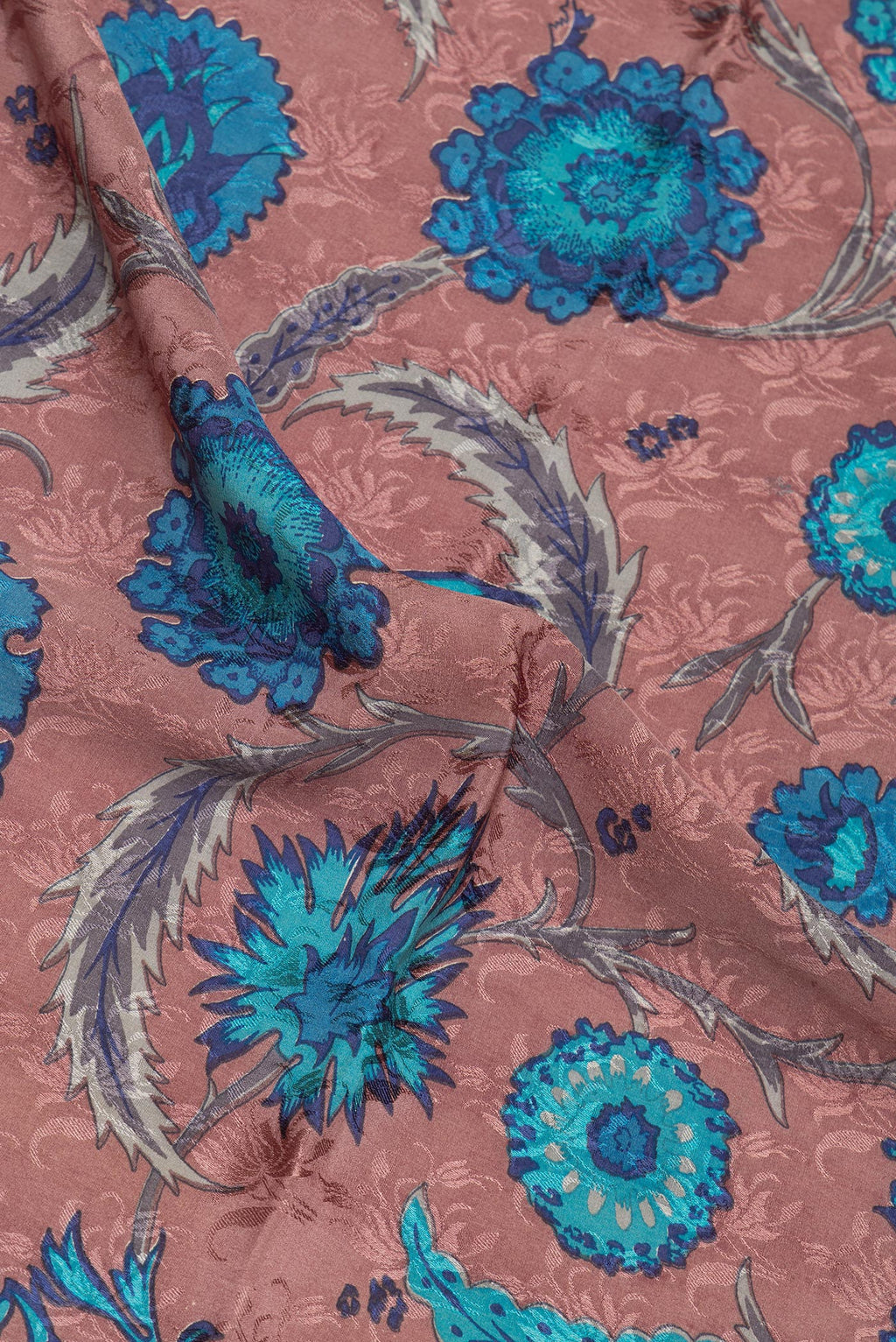 Close up of Brown Crepe Saree with Printed design on the body and Zari Border.  displaying folds