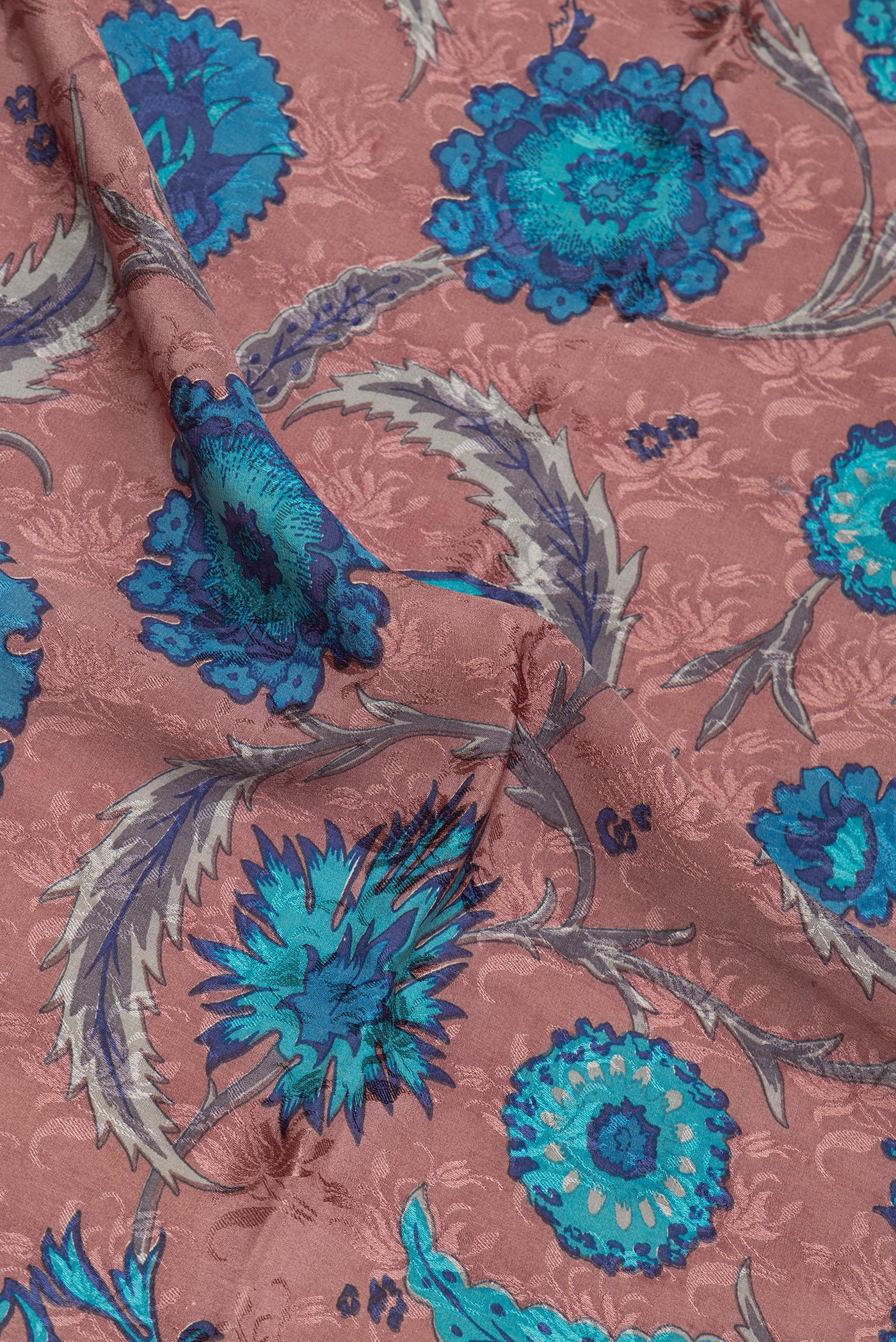 Close up of Brown Crepe Saree with Printed design on the body and Zari Border.  displaying folds
