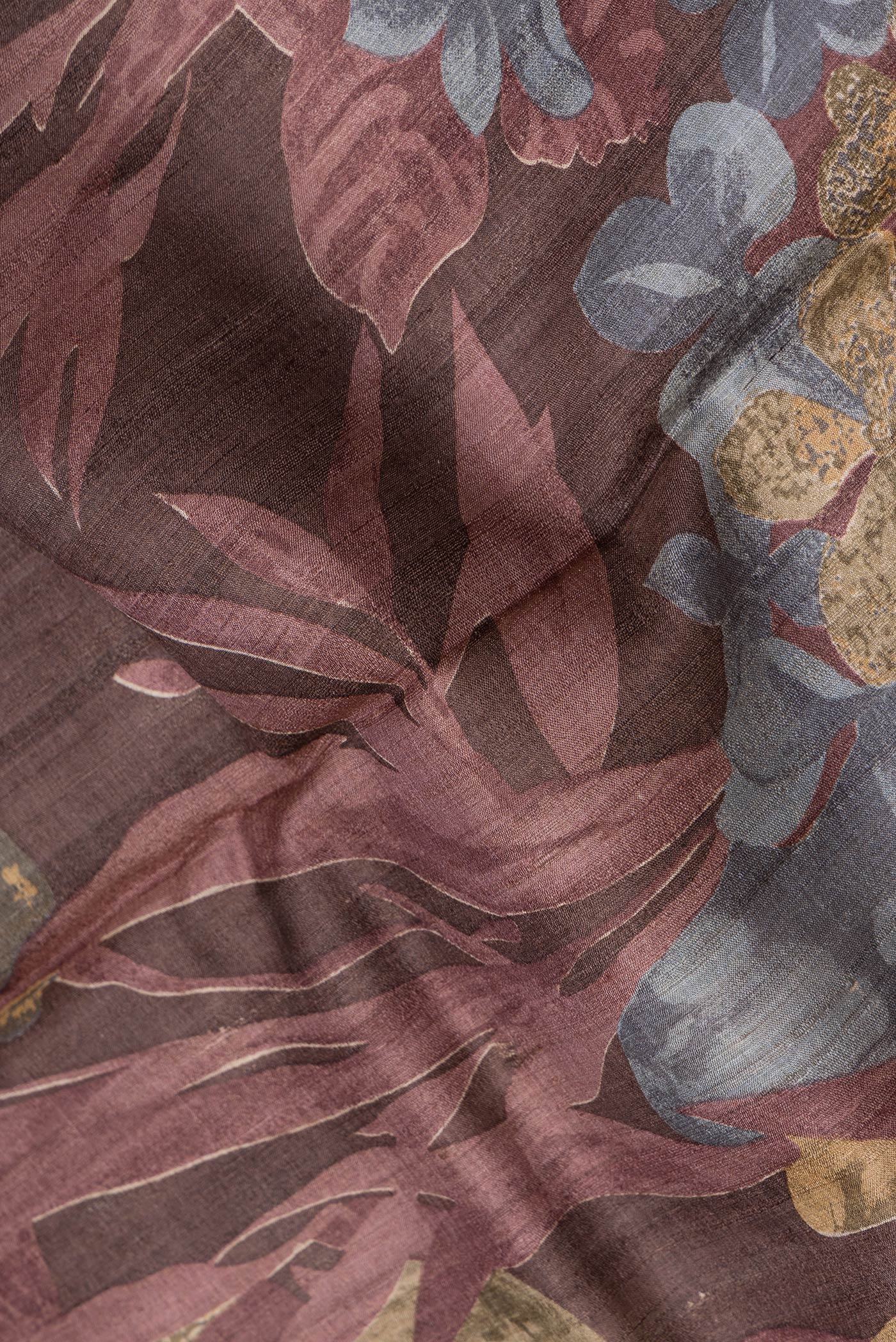 Close up of Maroon Dual Tone Tussar Silk Saree with Printed design on the body and Zari Border.  displaying folds