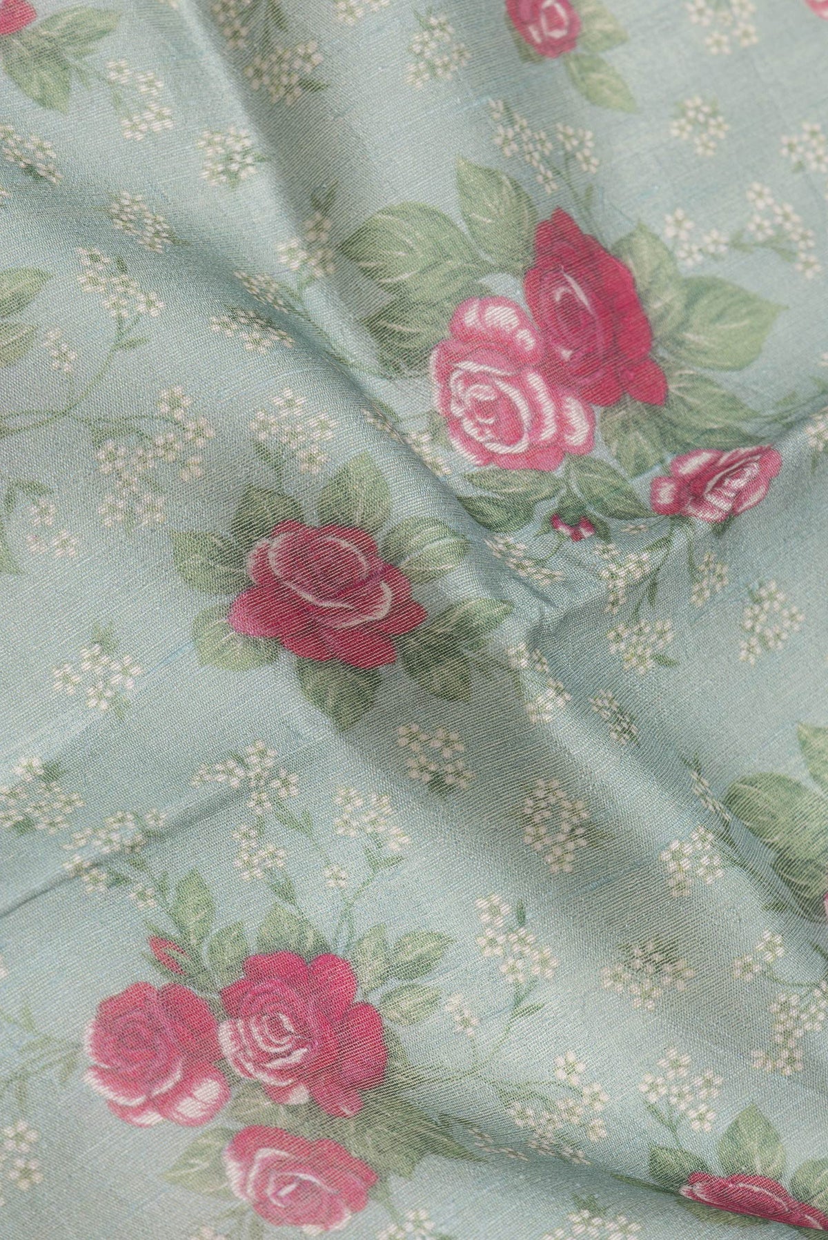 Close up of Green Dual Tone Tussar Silk Saree with Printed design on the body and Zari Border.  displaying folds