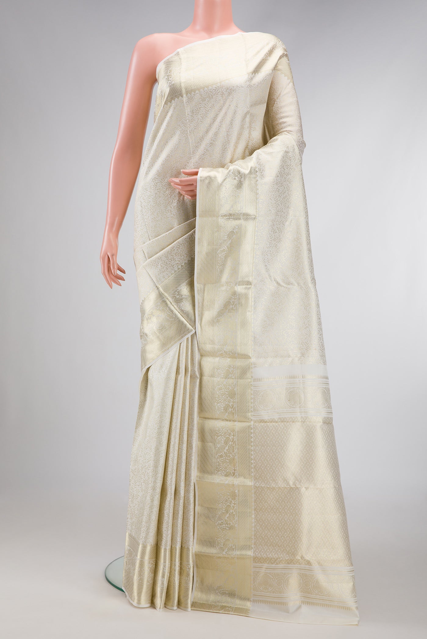 Off White Kanchipuram Silk Saree with Zari Brocade on the body and Zari Border.  displayed on a mannequin