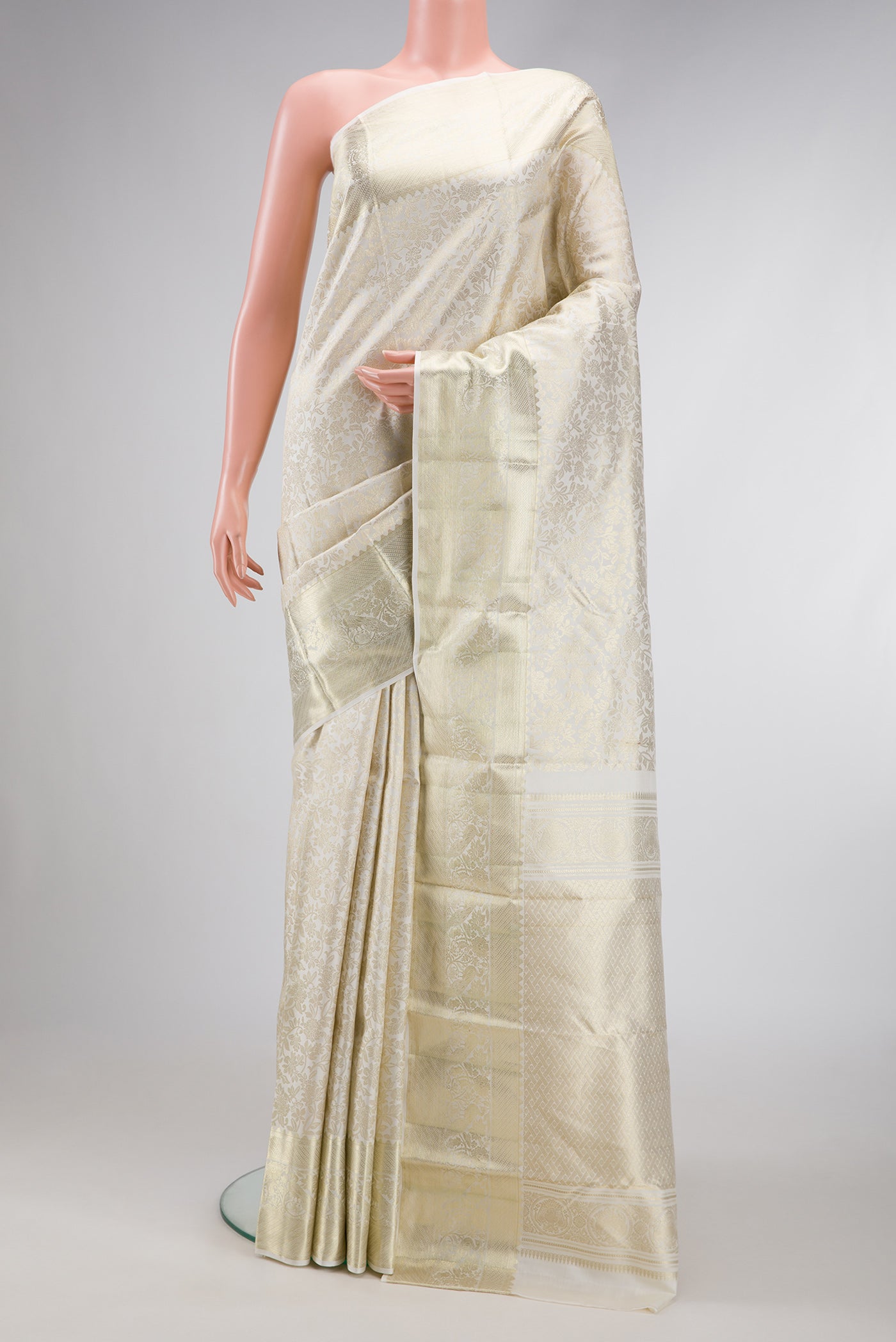 Off White Kanchipuram Silk Saree with Zari Brocade on the body and Zari Border.  displayed on a mannequin